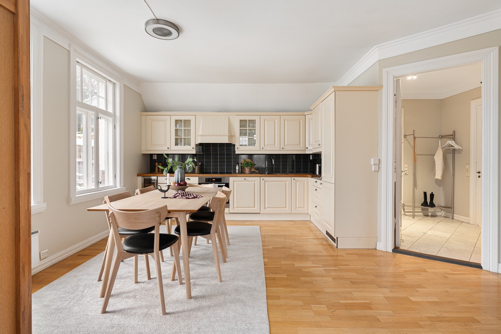 Kjøkkenet har innredning med profilerte fronter, kitchenboard over benk. Benkeplaten er av heltre. Det er kjøl/fryseskap, oppvaskmaskin, induksjonstopp, vinskap, kaffemaskin og stekeovn.