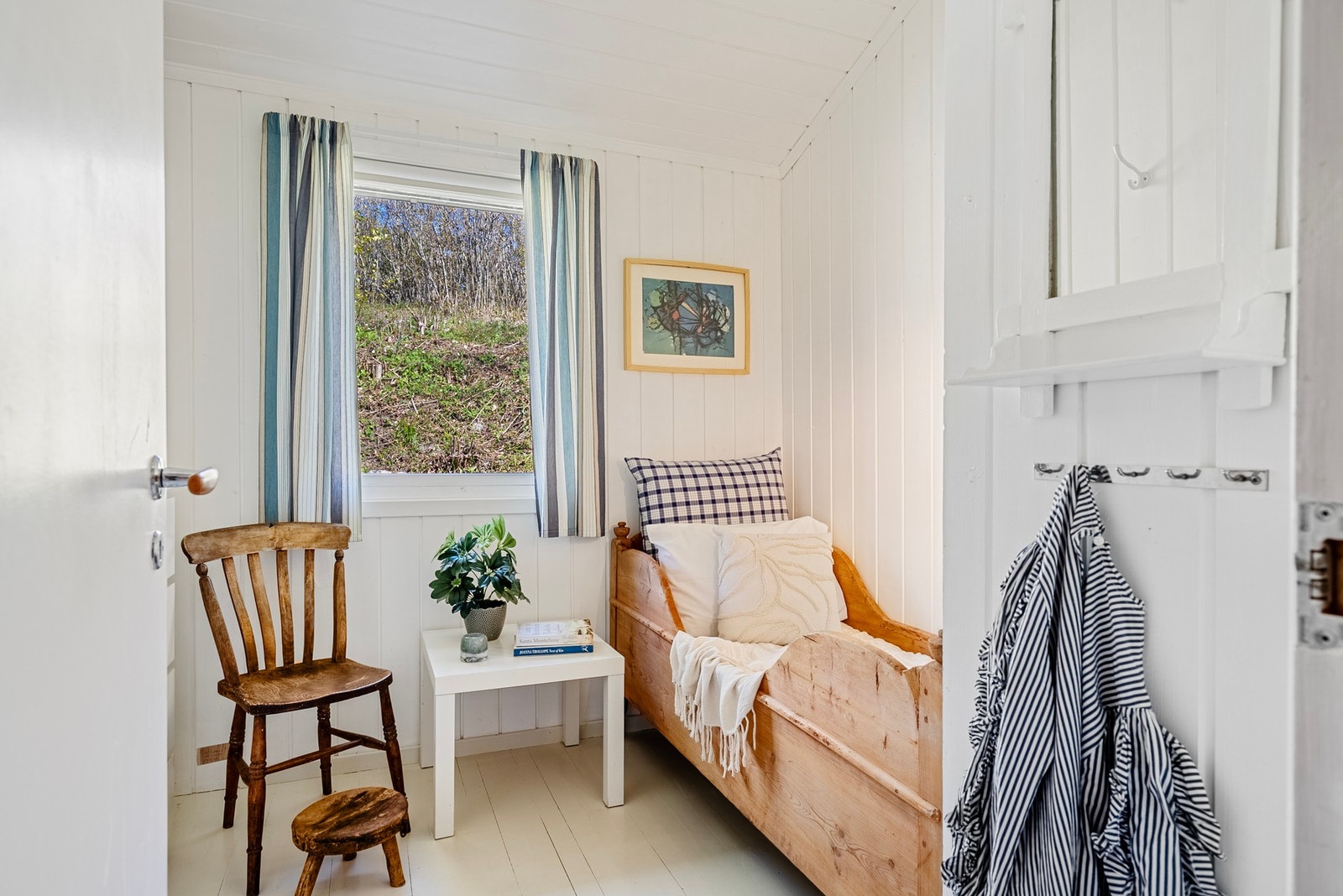 Sommeridyll med malt panel og tregulv som skaper en lun og klassisk hyttestemning Galleribilde