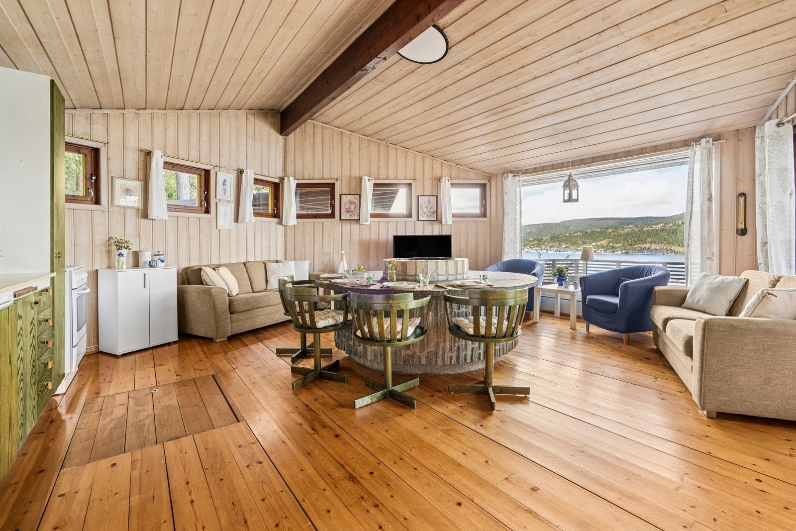 Åpen stue- og kjøkkenløsning med store vindusflater mot fjorden som slipper inn godt med dagslys og gir flott kontakt med omgivelsene. Galleribilde