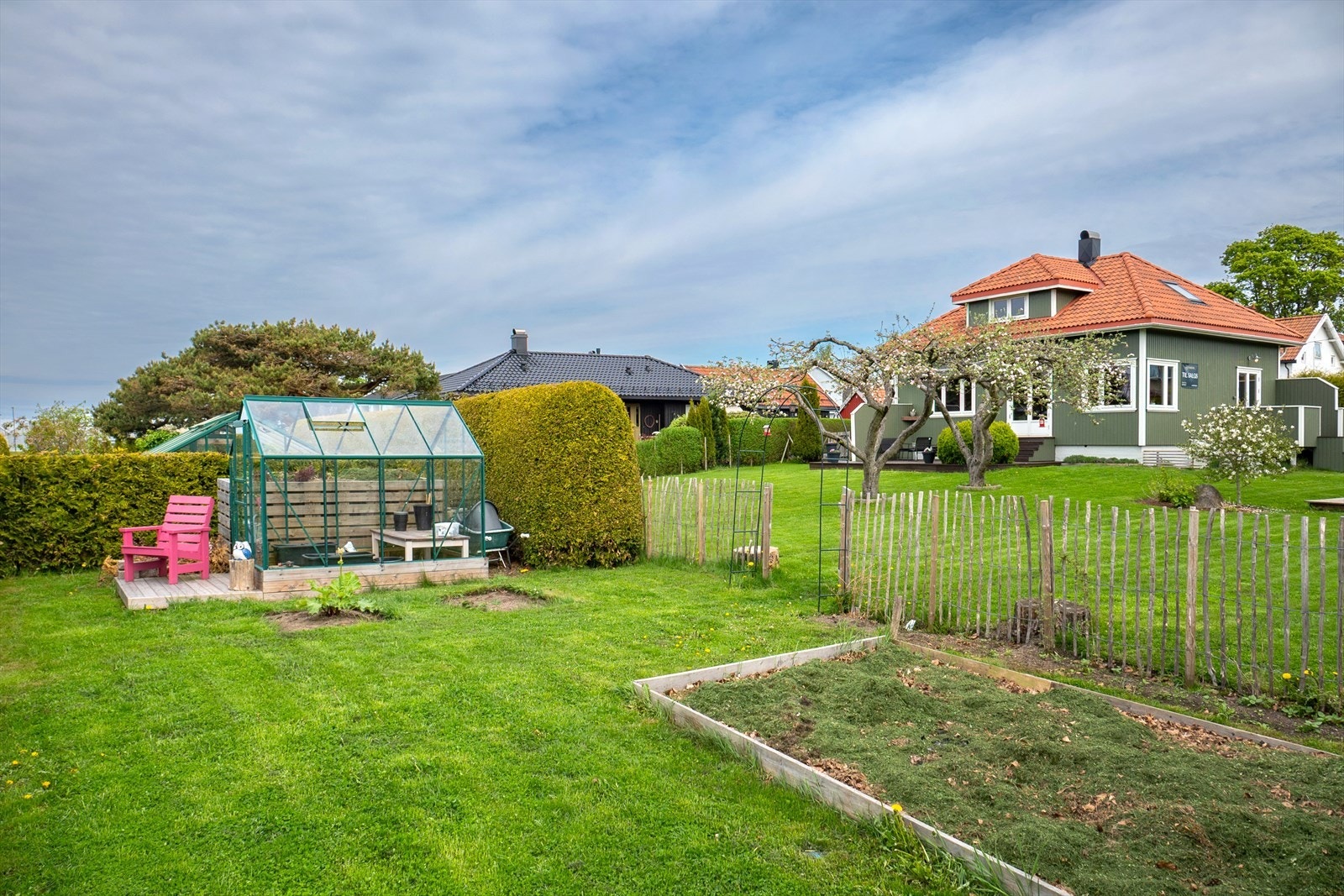 Her finnes en kombinasjon av åpne terrasseflater, skjermede soner og en egen kjøkkenhage med drivhus - ideelt for deg med grønne fingre. Galleribilde