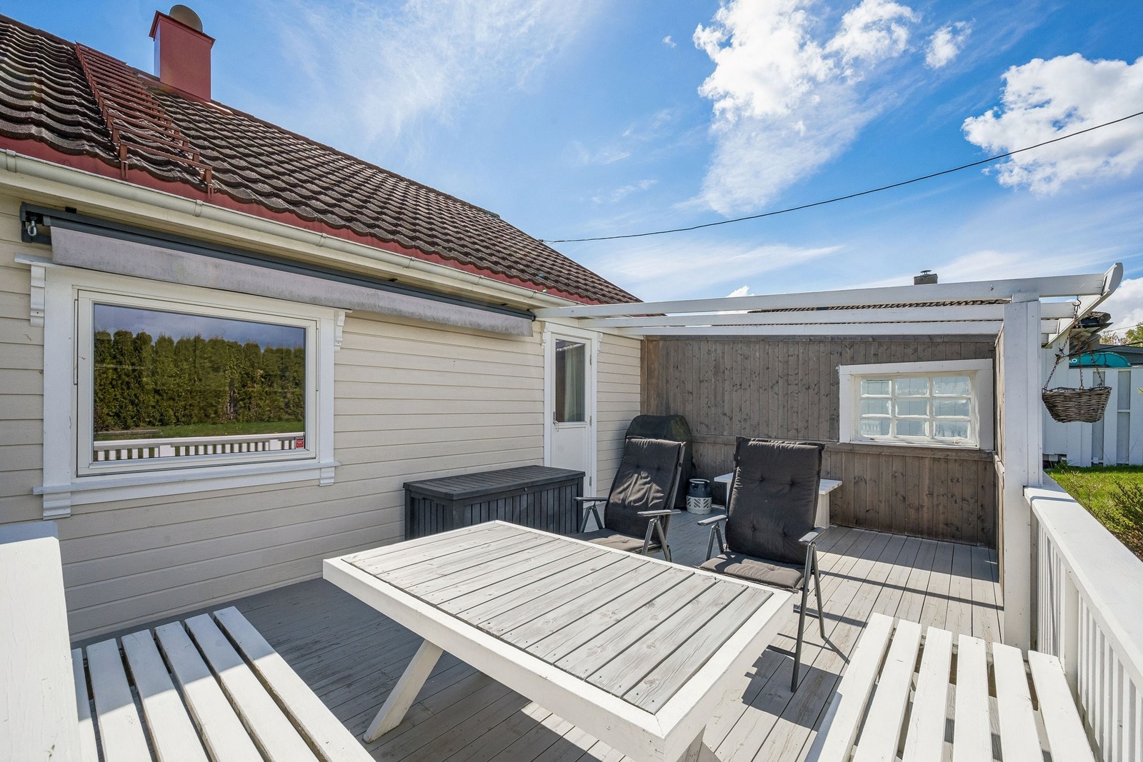 Terrasse ut fra spistestue og foran kjøkkenvindu. Flott utsikt også her. Markise. Galleribilde