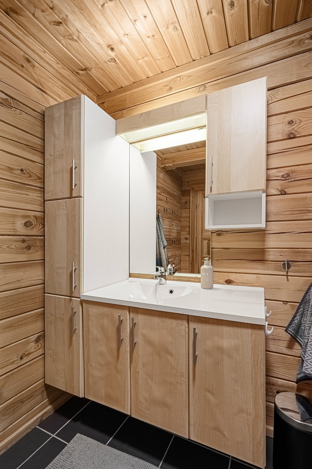 Badet inneholder servant m/skap, dusjkabinett, wc og opplegg til vaskemaskin. Galleribilde