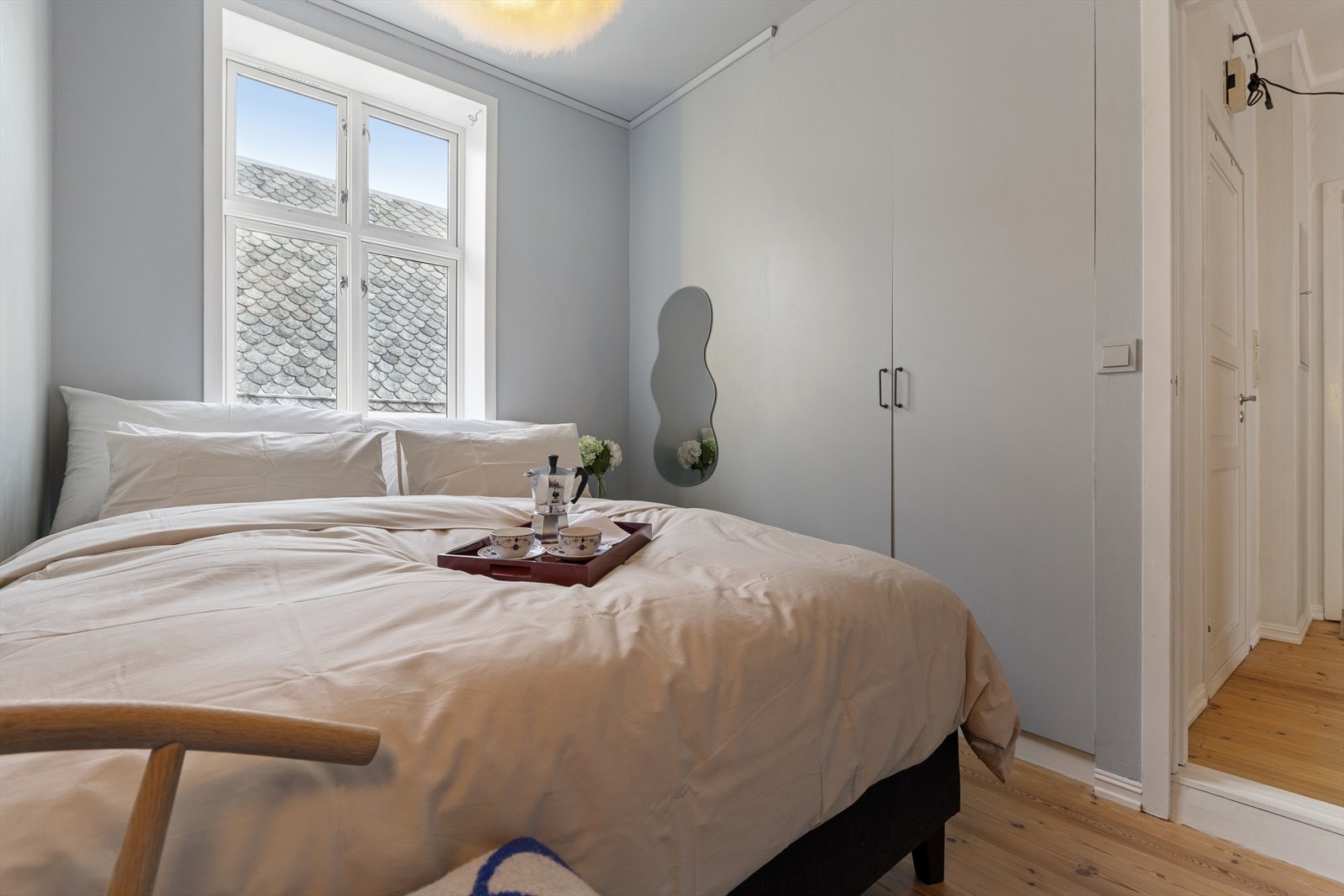 Rommet har plass til dobbeltseng med nattbord og det er et garderobeskap langs veggen mot entréen for praktisk oppbevaring. Galleribilde