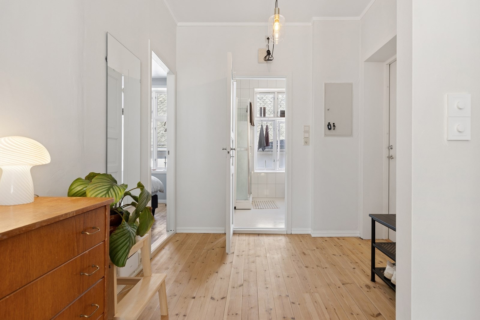 De malte innerdørene med profilert ramme er originale i uttrykket og passer godt til byggets alder. Fra entréen er det adkomst til bad, soverom og videre inn i stue- og kjøkkensonen. Galleribilde