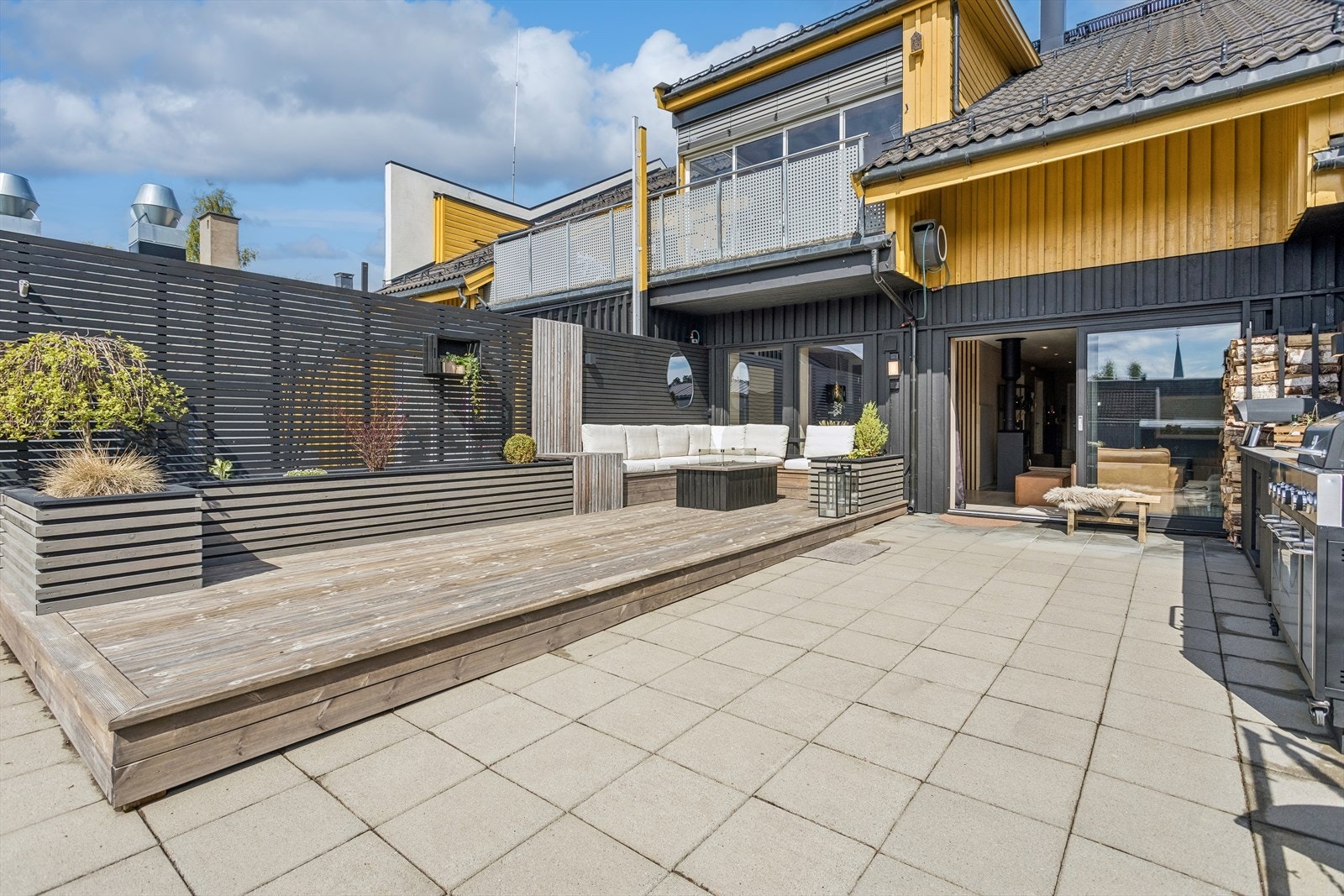 Takterrassen er delvis bygget opp som en markterrasse med impregnerte bord, og har ellers betongheller. Galleribilde
