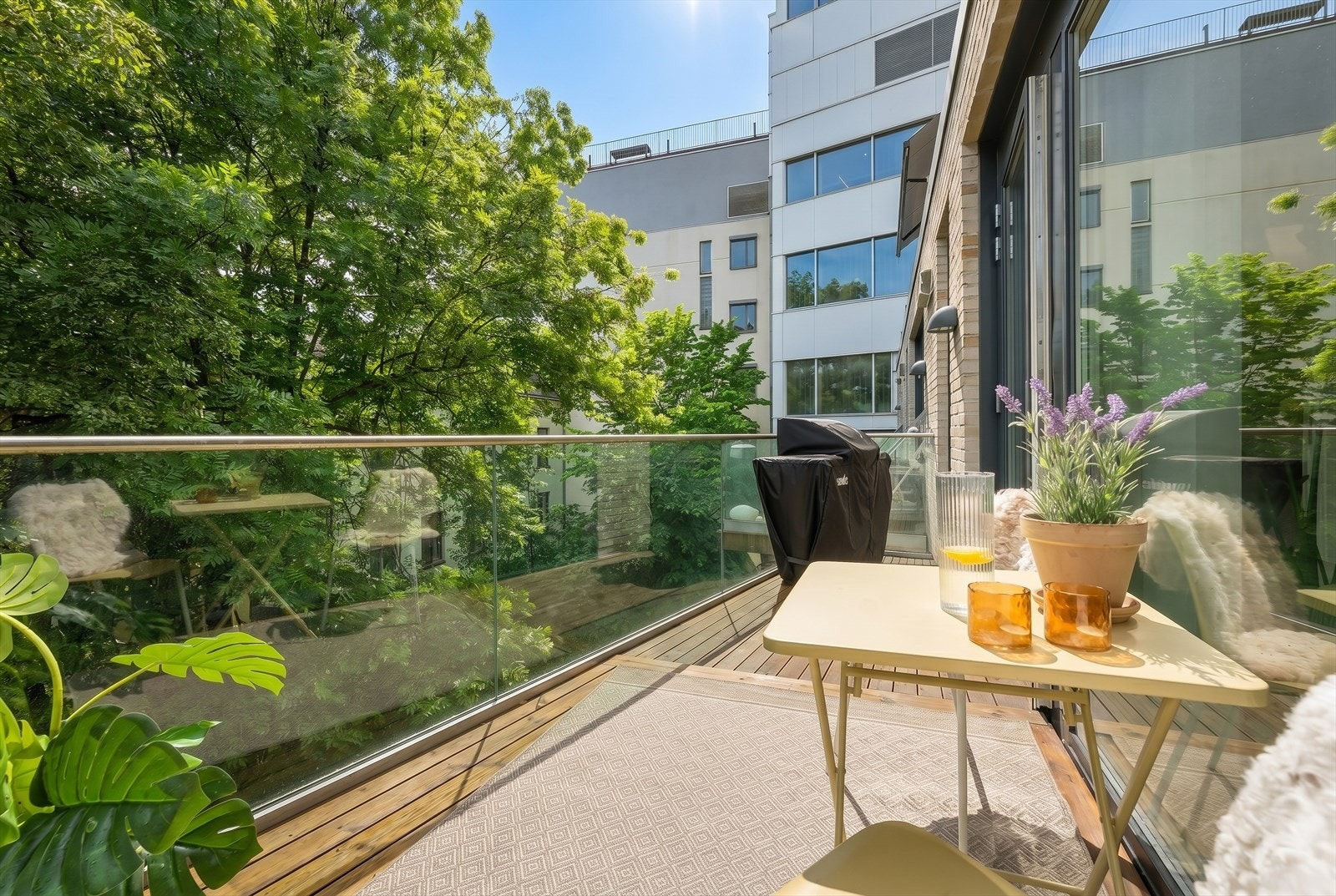 Vestvendt balkong med tregulv og rekkverk i glass, bygget i 2021. Galleribilde
