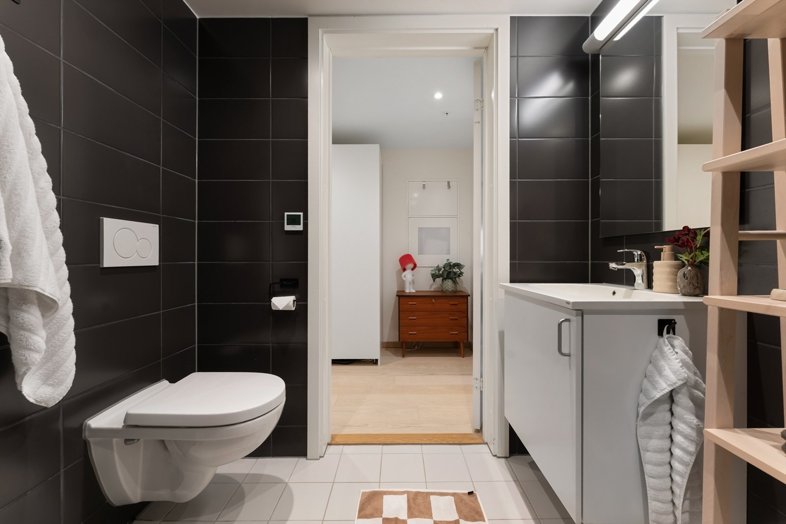 Badet er utstyrt med vegghengt toalett, servantinnredning og dusjhjørne med slukrenne. Galleribilde