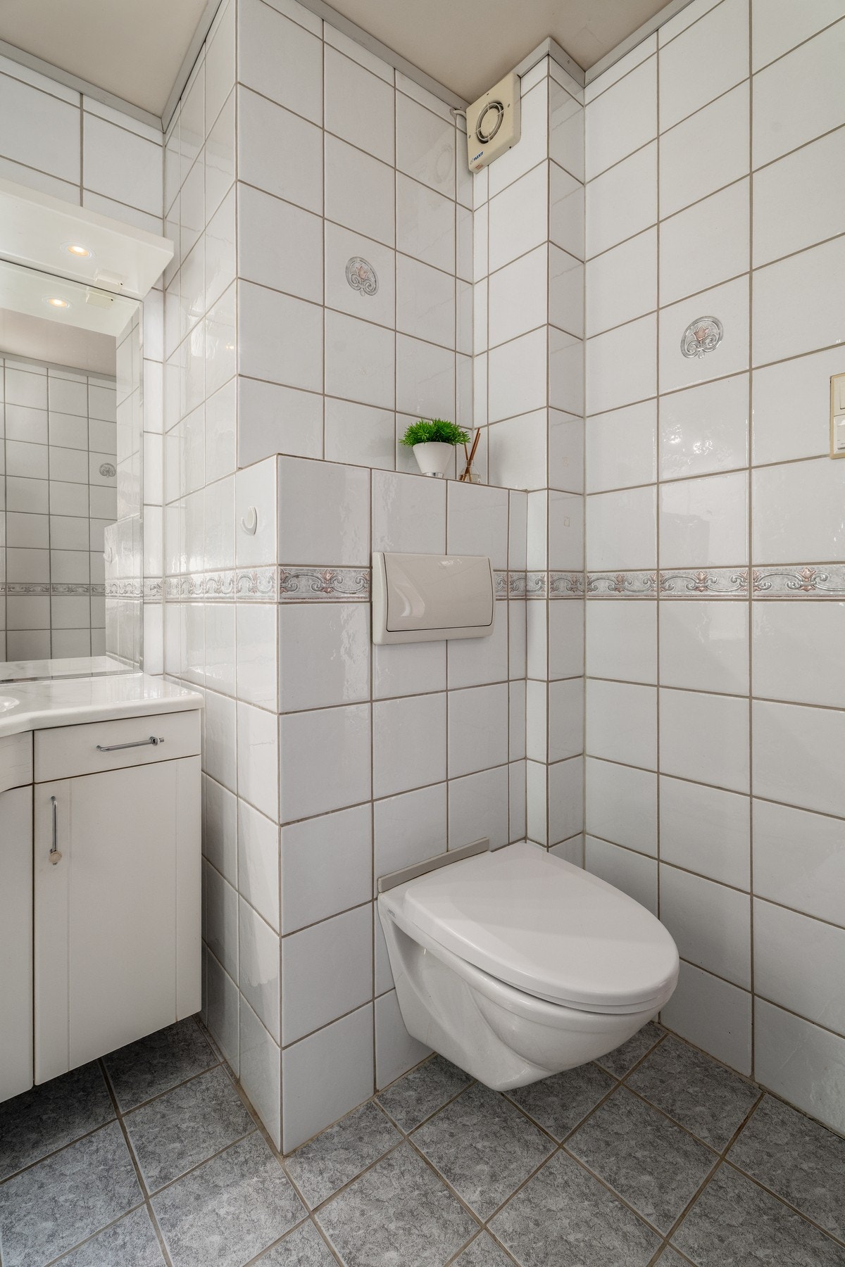 Badet i hovedetasjen har flislagte overflater og vegghengt WC. Galleribilde