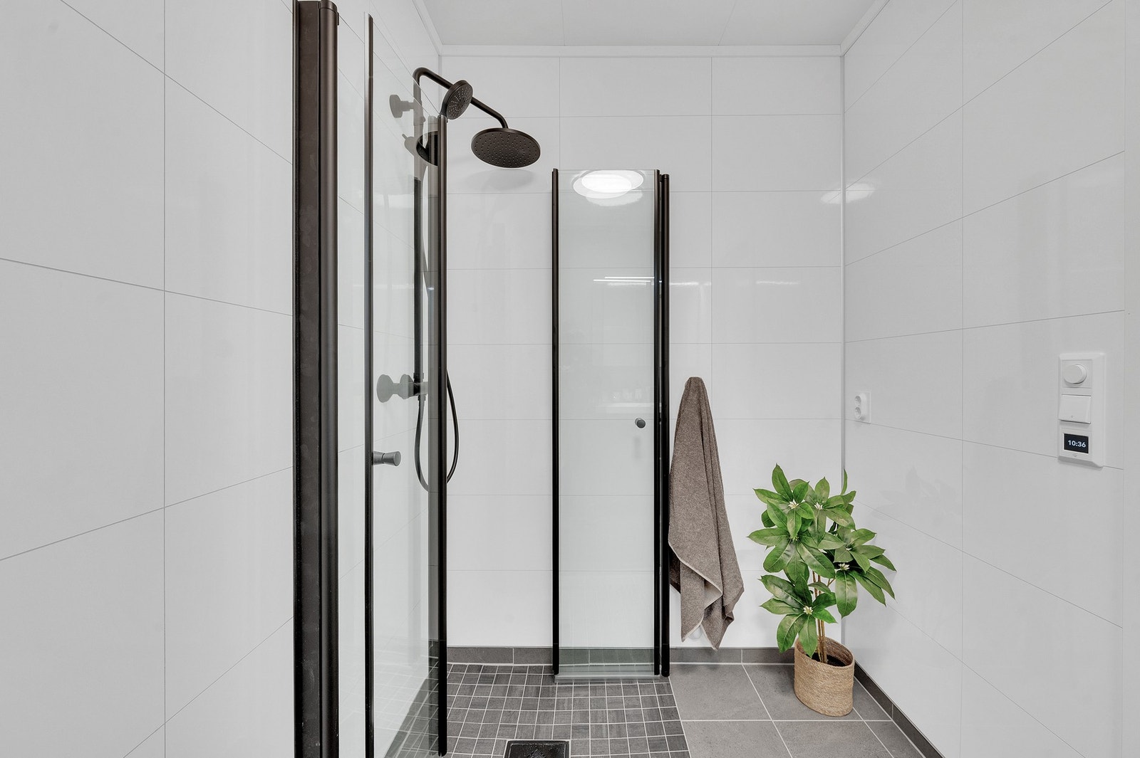Badet har et romslig dusjhjørne med innfellbare glassdører og praktisk opplegg for vaskemaskin. Galleribilde