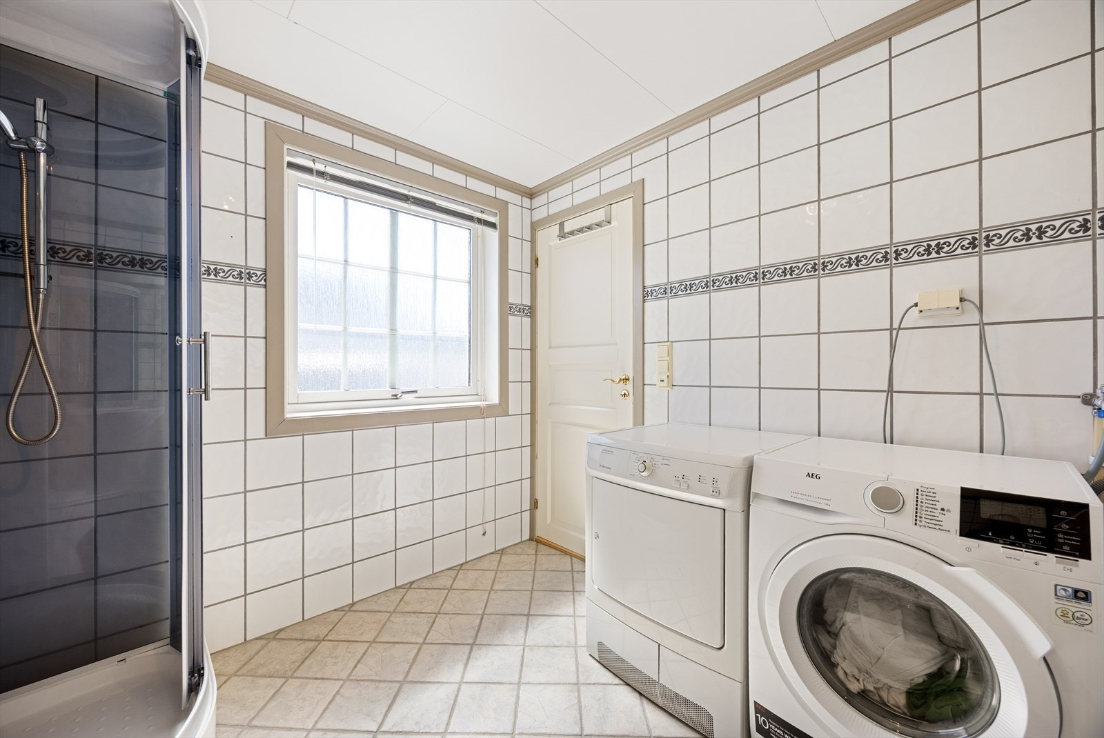 Badet er innredet med dusjkabinett, toalett og servant med oppbevaring. Galleribilde
