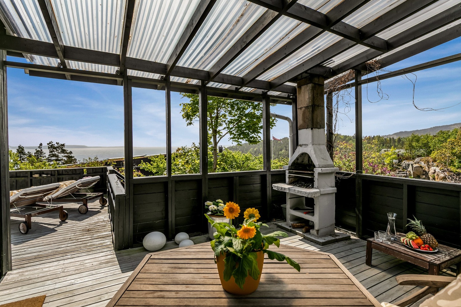 Direkte utgang fra stuen til lun overbygd del på terrassen . Galleribilde