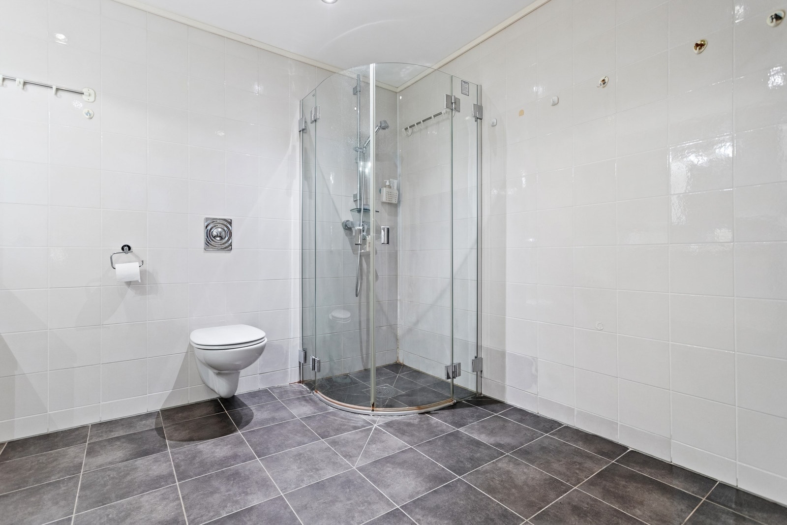 Badet er utstyrt med baderomsinnredning, dusjhjørne, vegghengt toalett og opplegg for vaskemaskin. Galleribilde
