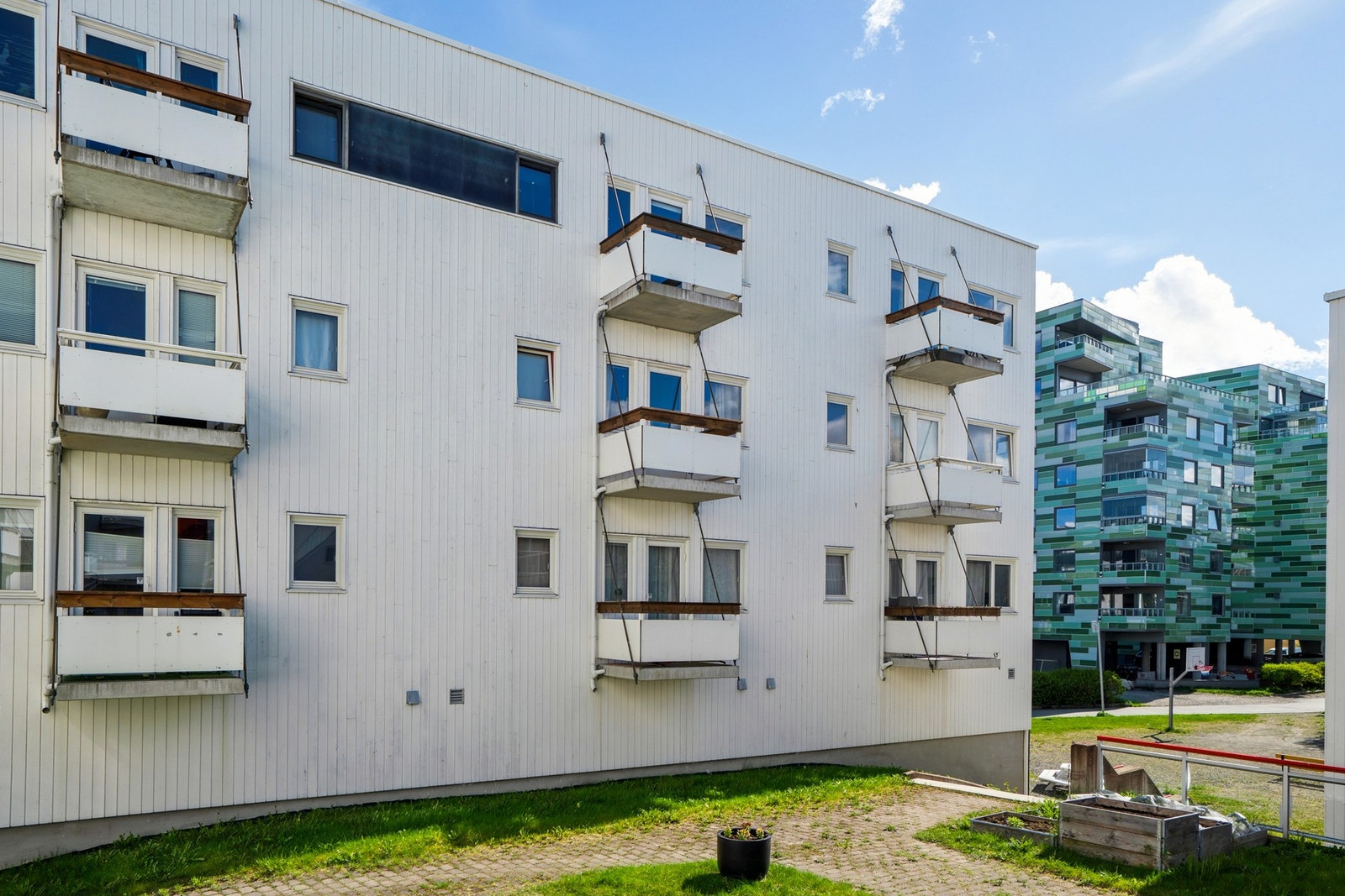 Bygningen er fra 2005 og har balkonger med malt trerekkverk. Galleribilde