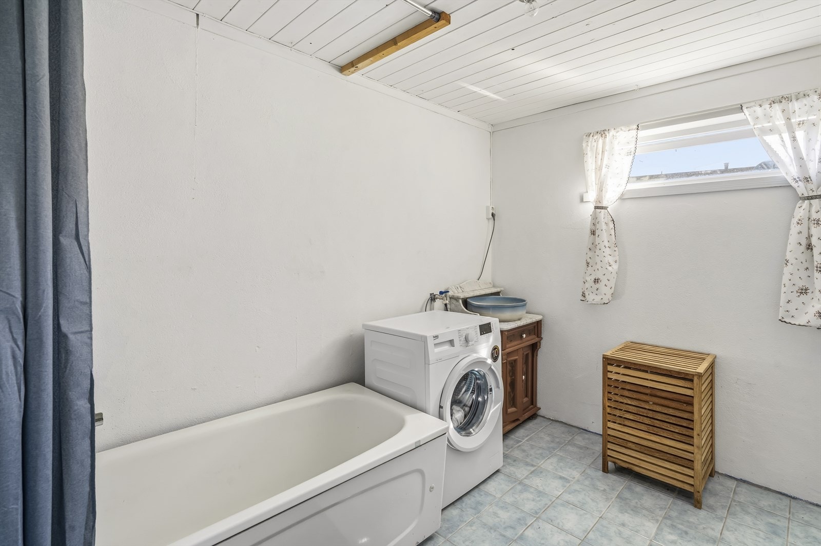 Vaskerommet i kjelleren er fra 1985 med malte betongvegger, flislagt gulv med varmekabler og sluk. Rommet er utstyrt med opplegg for vaskemaskin, vask og badekar. Galleribilde