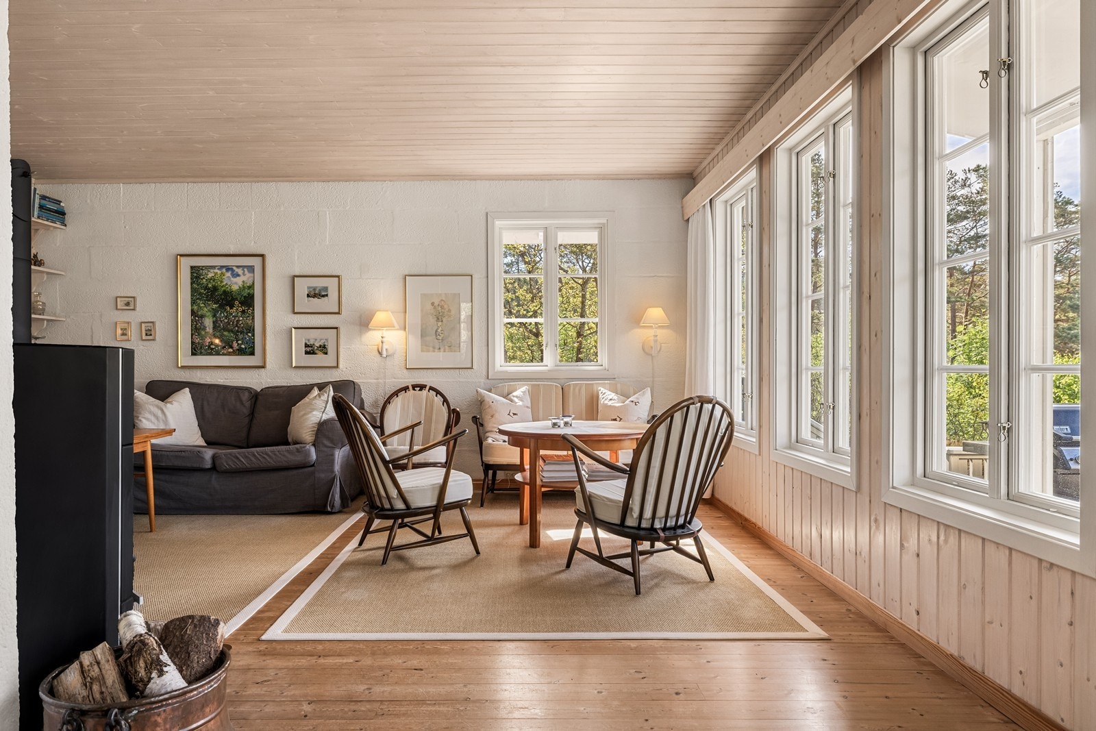 Stuen har god plass til flere sittegrupper. Veggene er kledd med trepanel og mur. Galleribilde