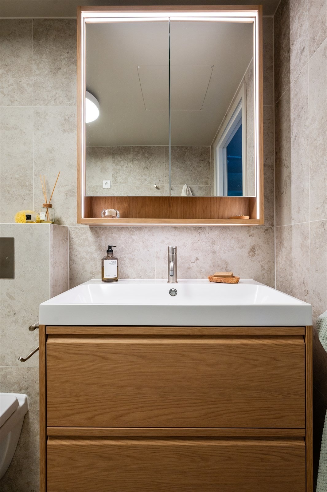 Badet er innredet med vegghengt toalett, servantinnredning med god oppbevaringsplass, dimbar belysning, samt speil med integrert belysning. Galleribilde