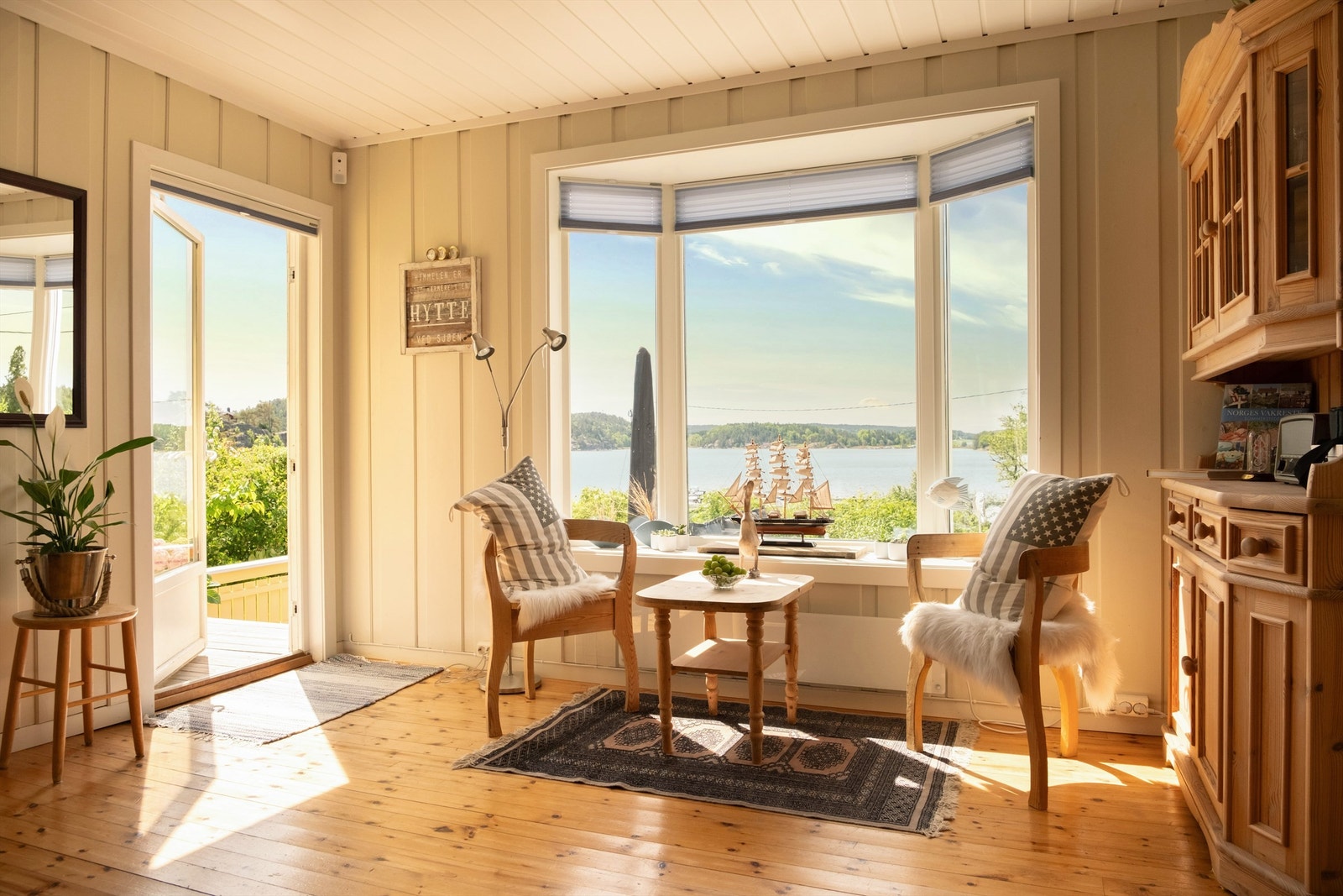 Moderne, toppmonterte plisségardiner fra Markisemannen er i senere år installert både i stuen og på kjøkkenet. Galleribilde