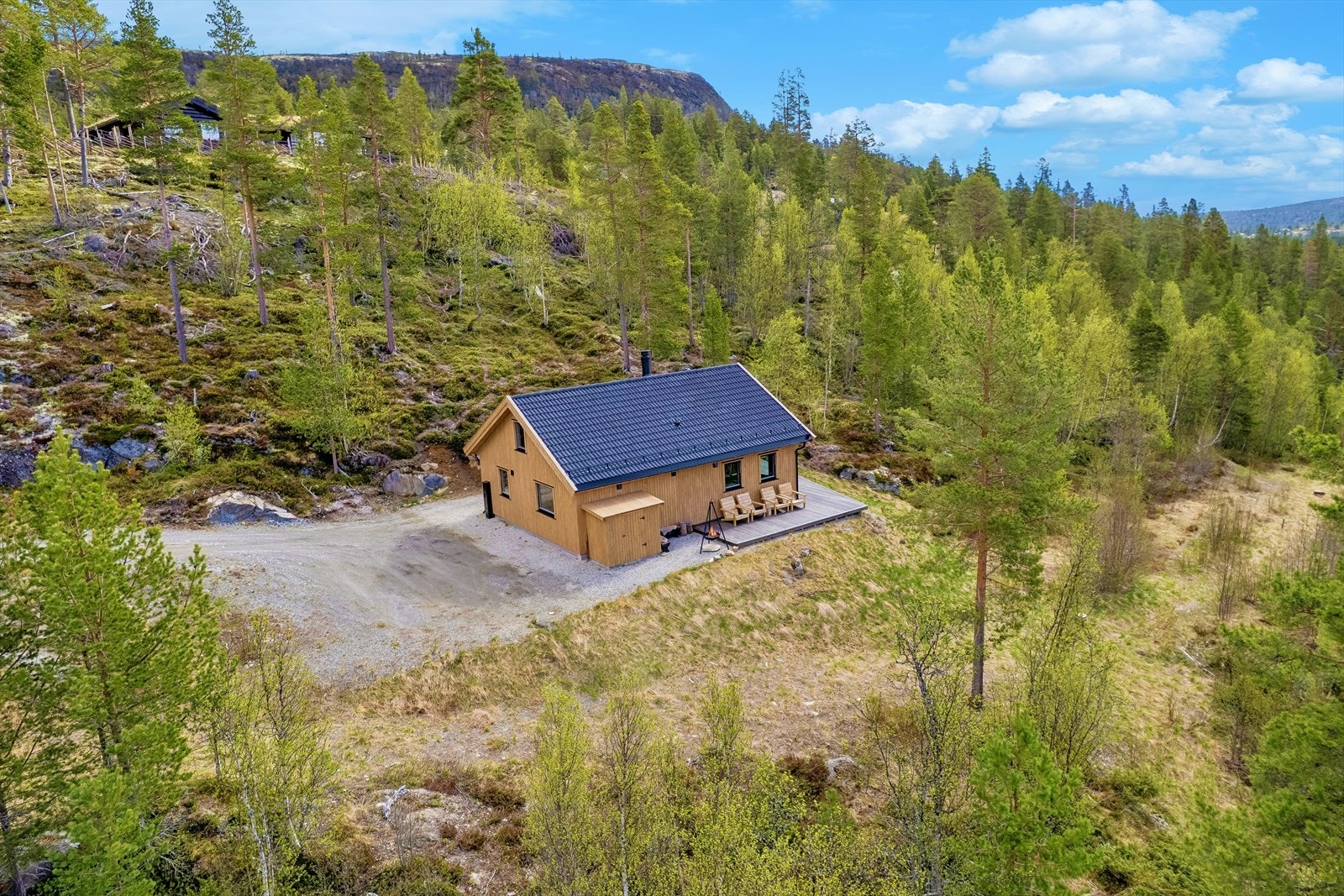 Tomten er omgitt av naturlig beplantning og fjellknauser. Galleribilde