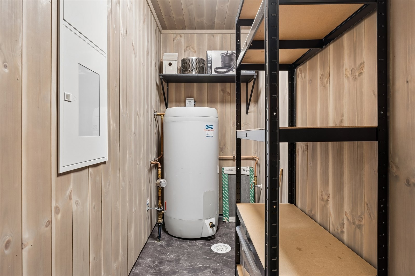 Teknisk rom med varmtvannsbereder på 194 liter fra 2022, sikringsskap og hovedstoppekran. Galleribilde