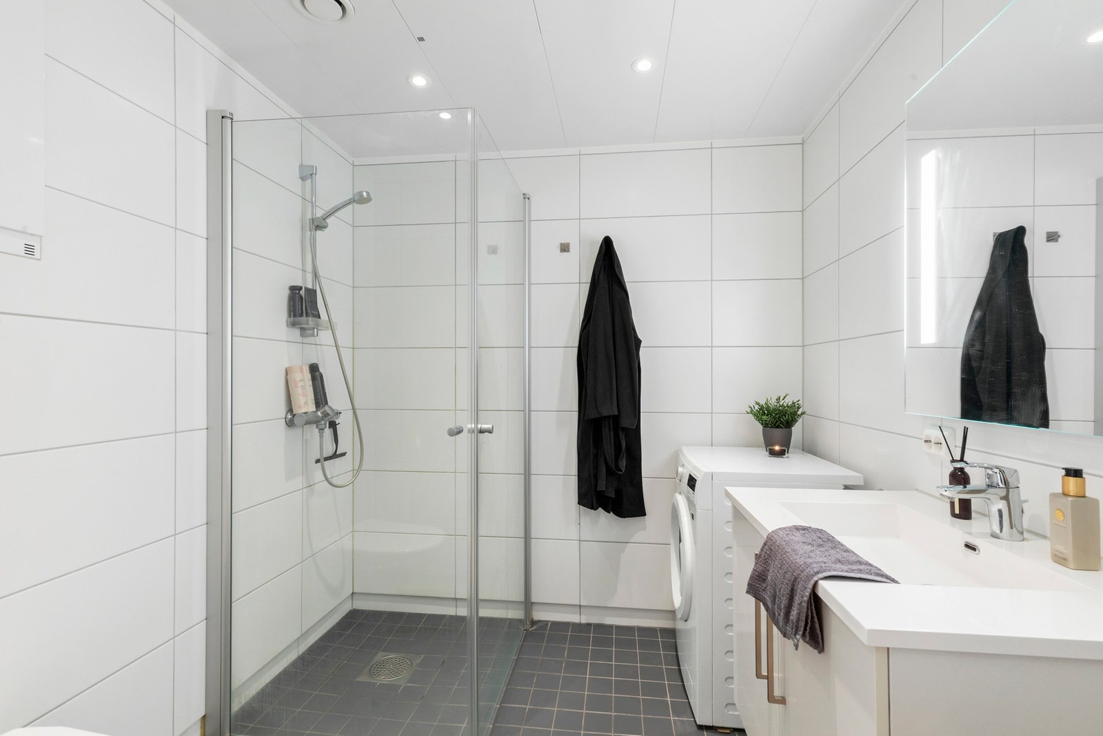 Innbydende bad med overflater av flis, behagelig gulvvarme og downlights i tak. Galleribilde