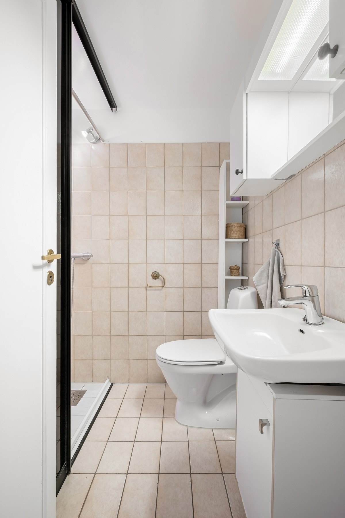 Det andre badet ligger i tilknytning til entréen og er fra ukjent år. Badet har flislagte gulv og vegger med varmekabler i gulv, og er utstyrt med dusjhjørne, baderomsinnredning med speil og gulvstående toalett. Galleribilde