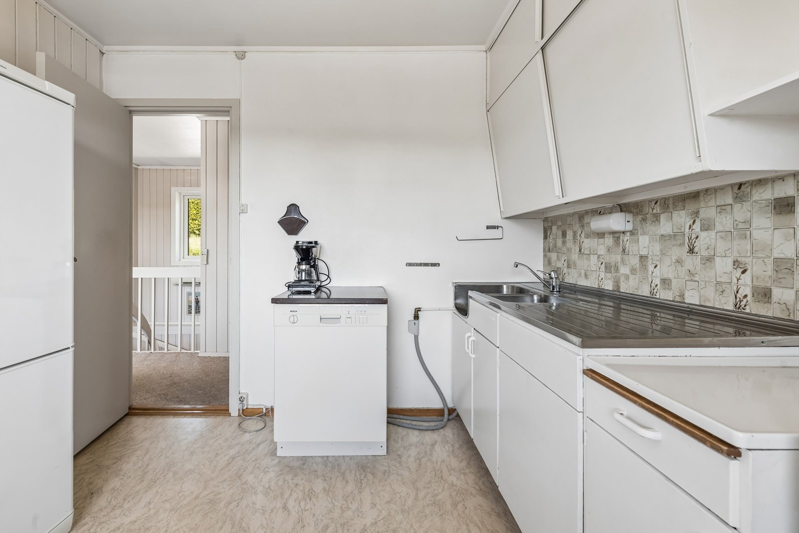 Kjøkkeninnredning med glatte fronter, laminatbenkeplate og opplegg for oppvaskmaskin. Galleribilde