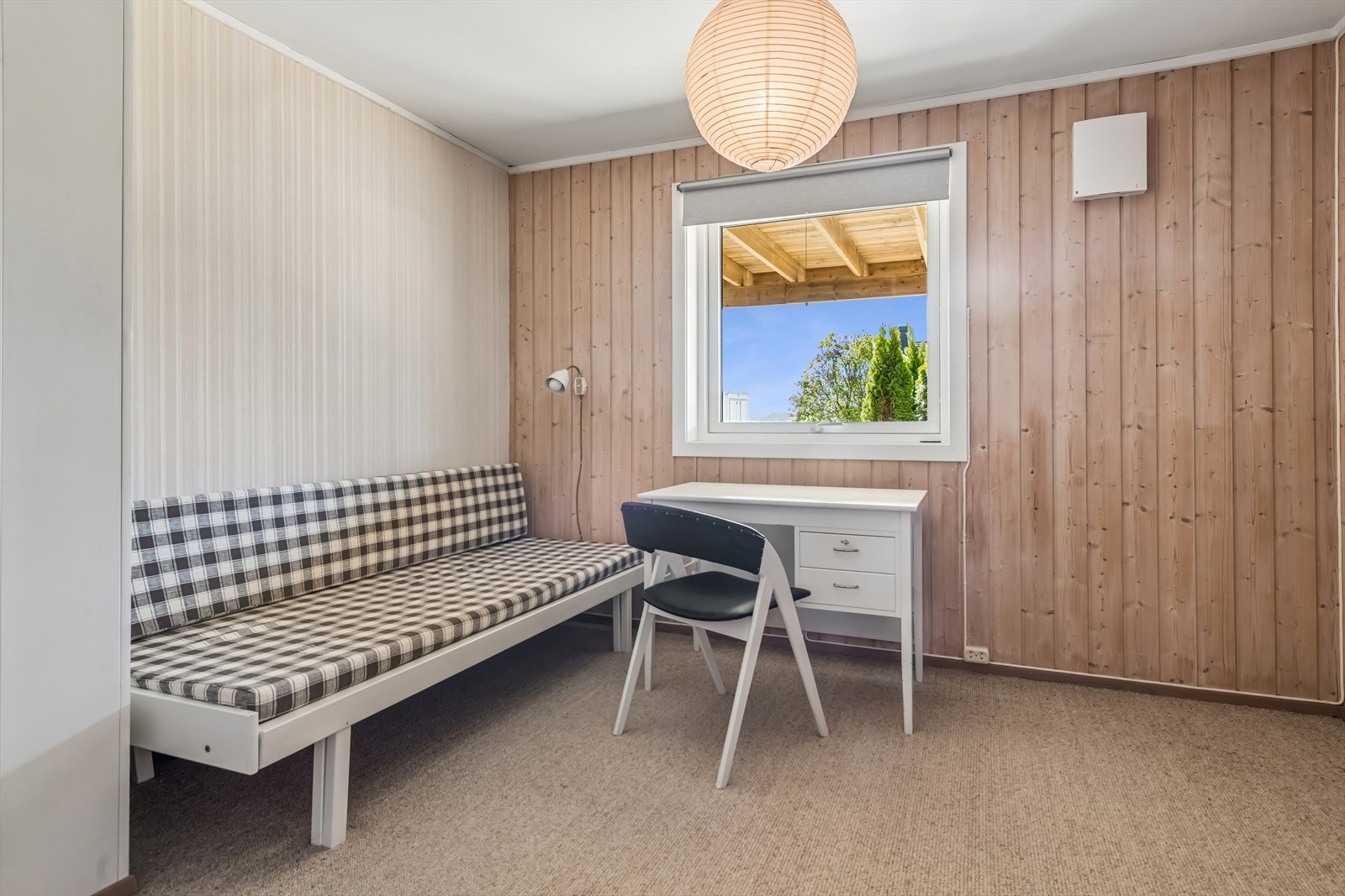 Det andre soverommet i underetasjen har veggflater med trepanel og malt strie. Galleribilde