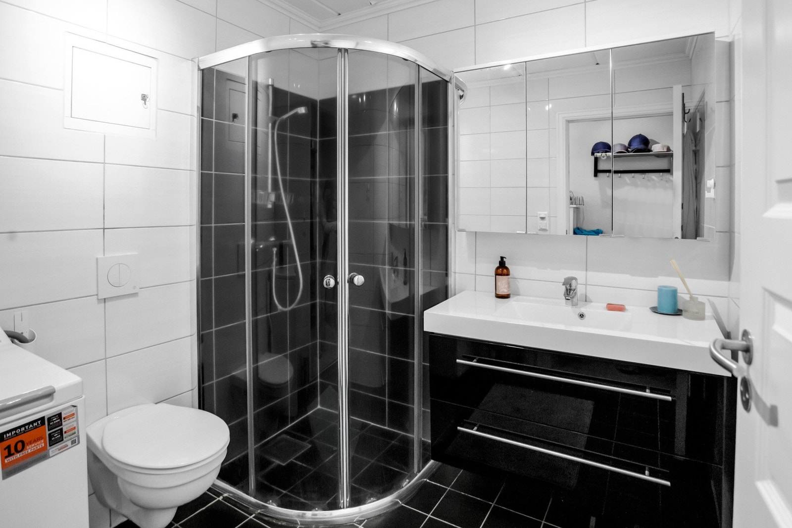 Badet har et moderne preg med store, lyse veggfliser og mørke gulvfliser som gir et tidløst uttrykk. Galleribilde