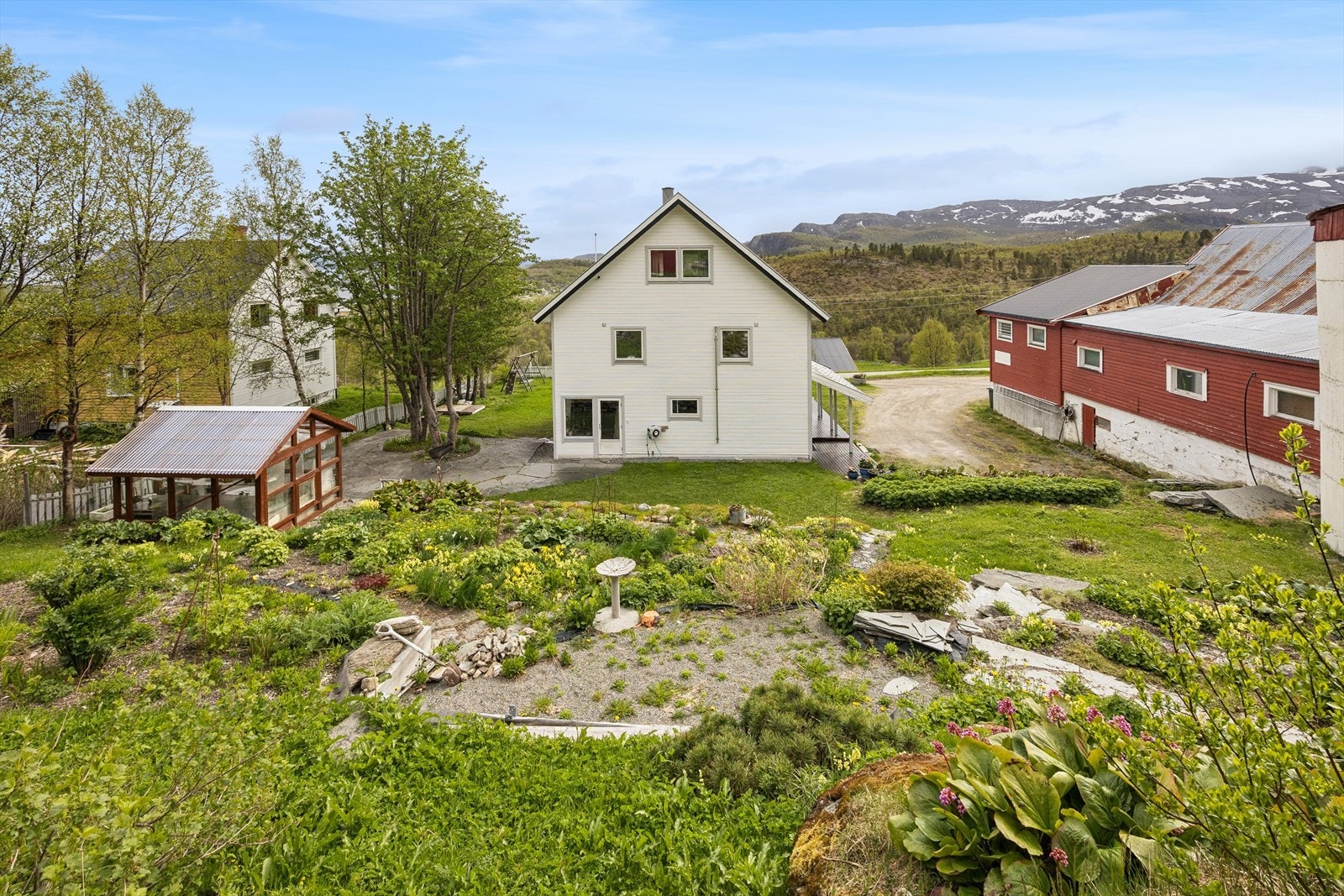 Tunet rundt eneboligen er opparbeidet med plen og ulik beplantning. Galleribilde