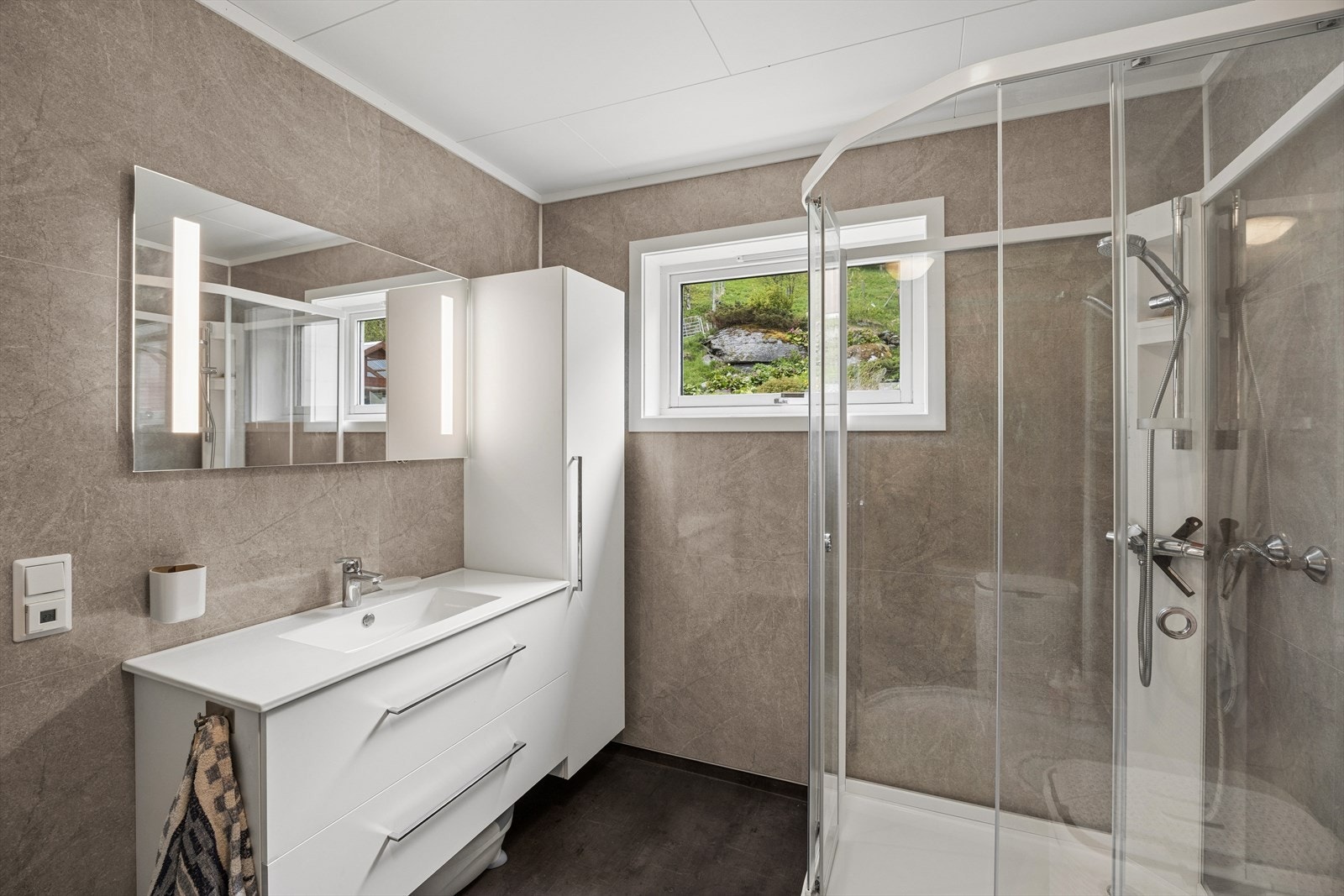 Badet i første etasje har moderne innredning med servant og speilskap. Galleribilde