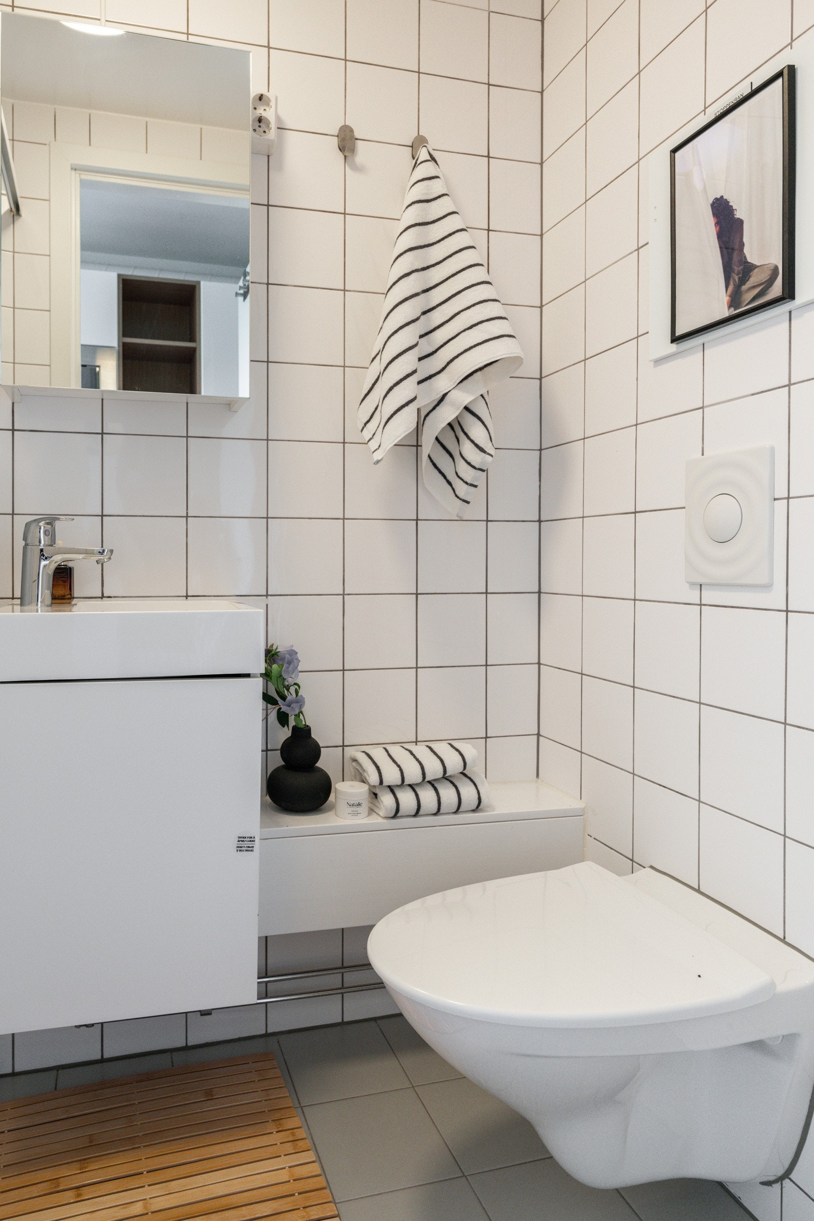 Baderommet er utstyrt med lyst servantskap med speilskap over, dusjnisje med delevegg og vegghengt toalett. Galleribilde