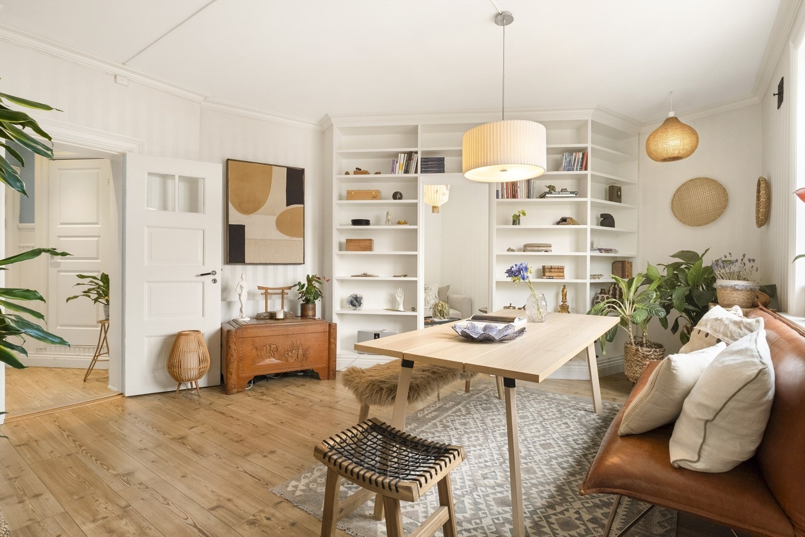 Plassbygde bokhyller, brede lister og lun tapet. Her er det mange detaljer som gjør at du får hjemmefølelsen. Galleribilde