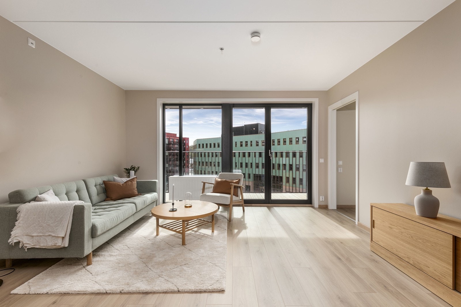 Stuedelen med balkongen i bakkant av bildet sett fra spiseplassen/kjøkkenet. Galleribilde
