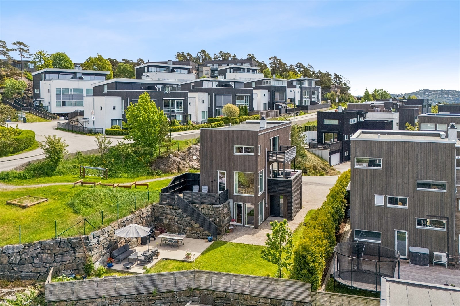 Eiendommen er pent opparbeidet med plen, støpt platting og forstøtningsmurer i naturstein. Galleribilde