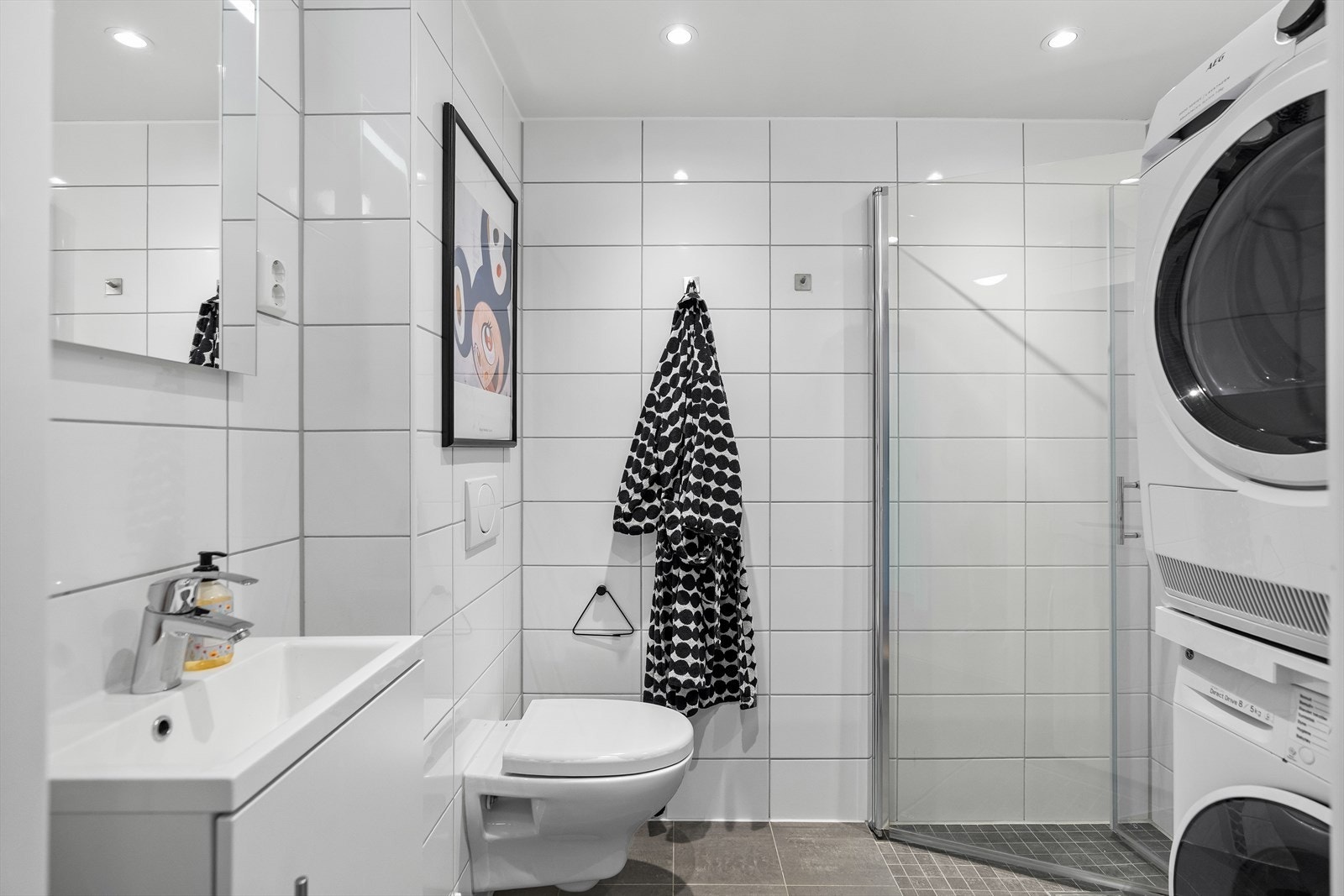 Rommet har innredning bestående av et underskap, servant, speil med lys, stikk og et nedsenket dusjhjørne. Det er tilkoblet et vannklosett og opplegg for vaskemaskin/tørketrommel. Galleribilde