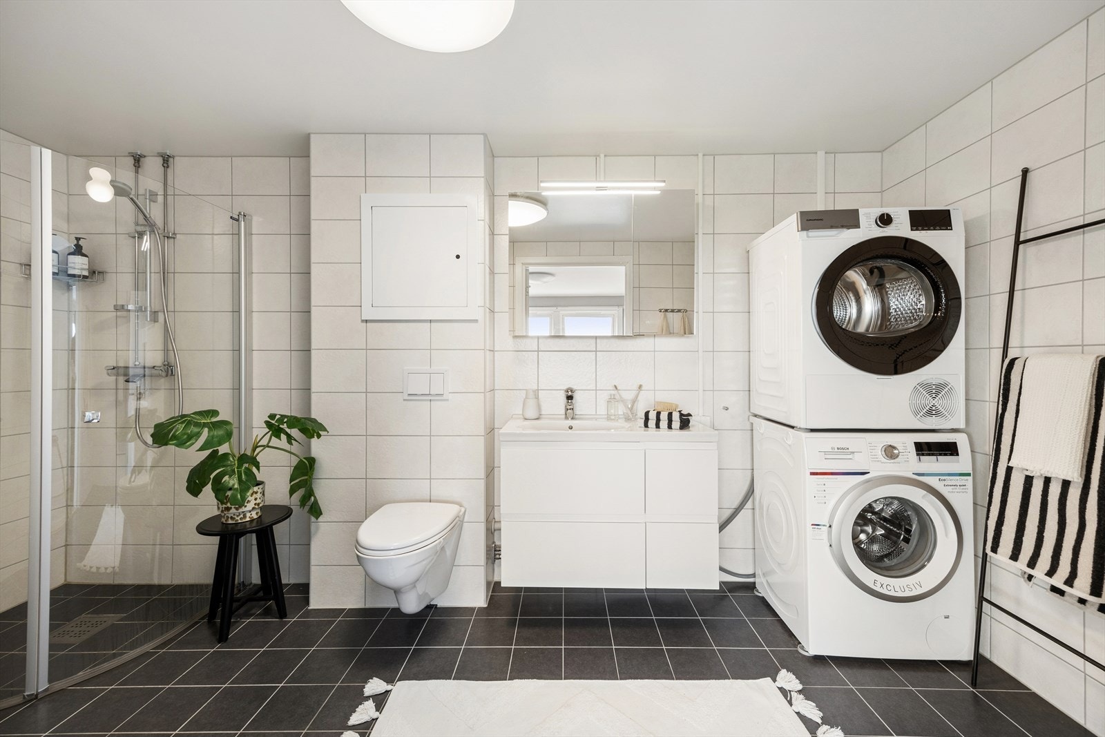 Et stort og lyst baderom nytt i 2018. Tidløse fliser, minimalistisk baderomsinnredning og innfellbare buede dusjdører. Opplegg for vaskemaskin. (Vaskemaskin og tørketrommel medfølger ikke, se vedlegg "Innbo og løsøre" for mer informasjon) Galleribilde