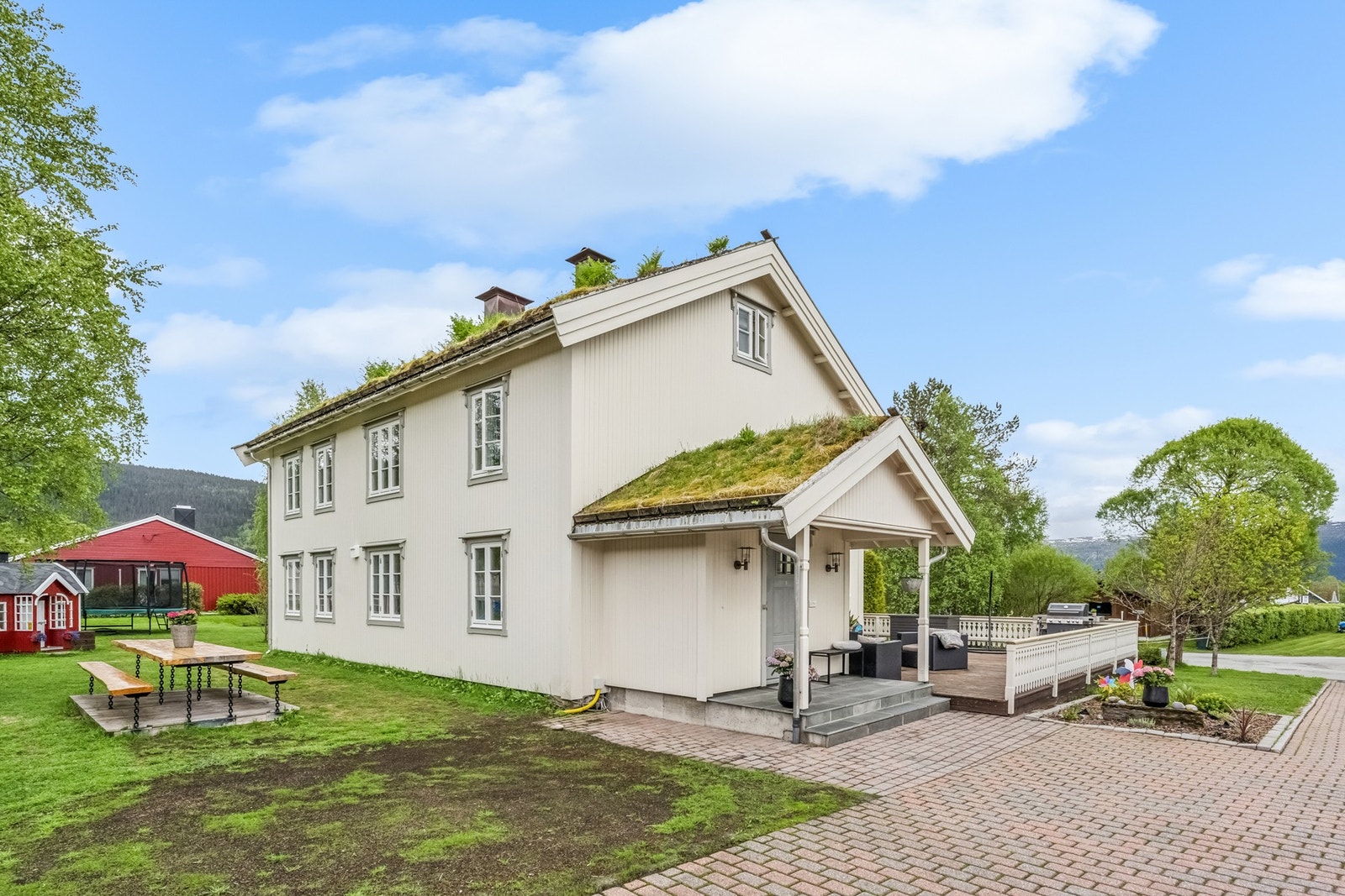 Våningshuset har stående perlestaff kledning og et karakteristisk torvtak. Galleribilde