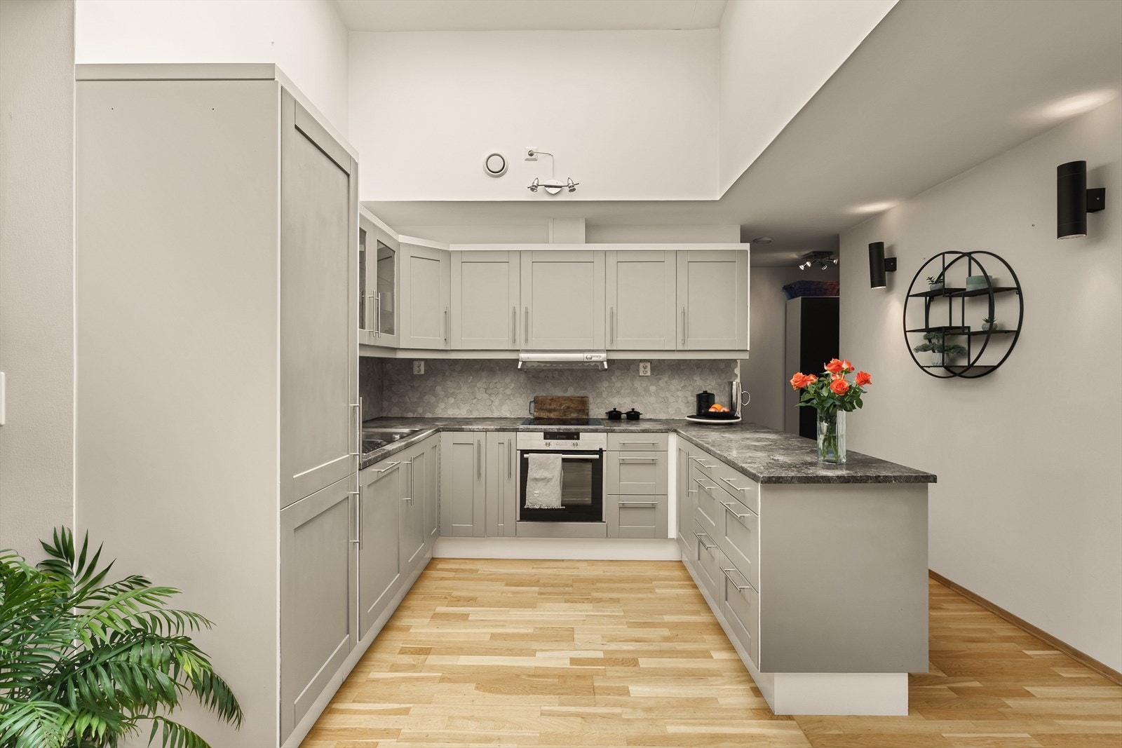 Kjøkkenet har innredning med profilerte fronter og overskap med glassfronter. Det er utstyrt med laminert benkeplate, stål vaskekum, ventilator, komfyrvakt og kitchen board over benkeplaten. Galleribilde