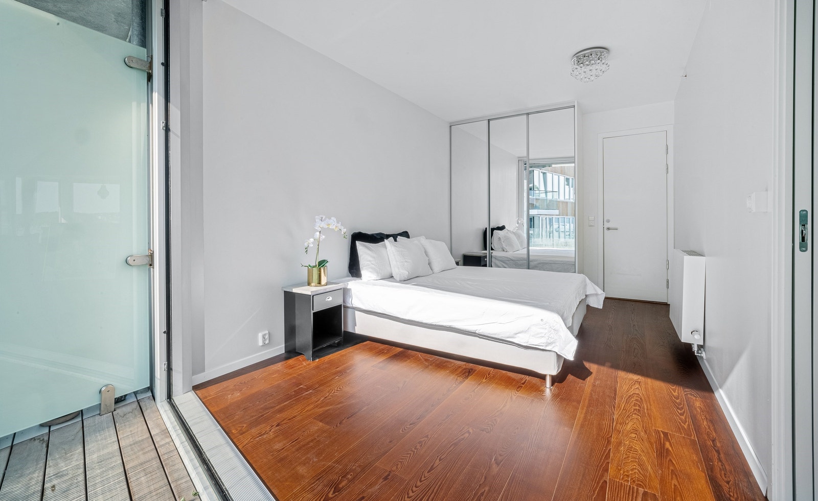 Stort soverom med skyvedørsgarderobe - dør til bad i bakgrunnen. Galleribilde