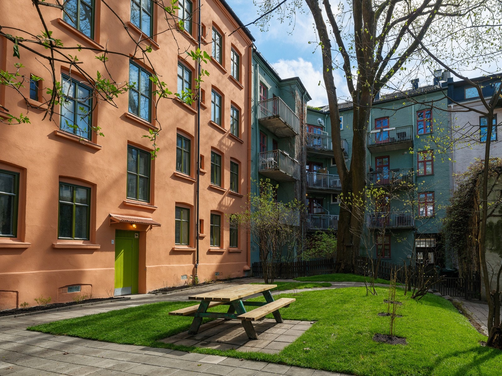 Bakgården er oppgradert i 2026 med heller, gressplen, beplantning og sittebenk. Galleribilde