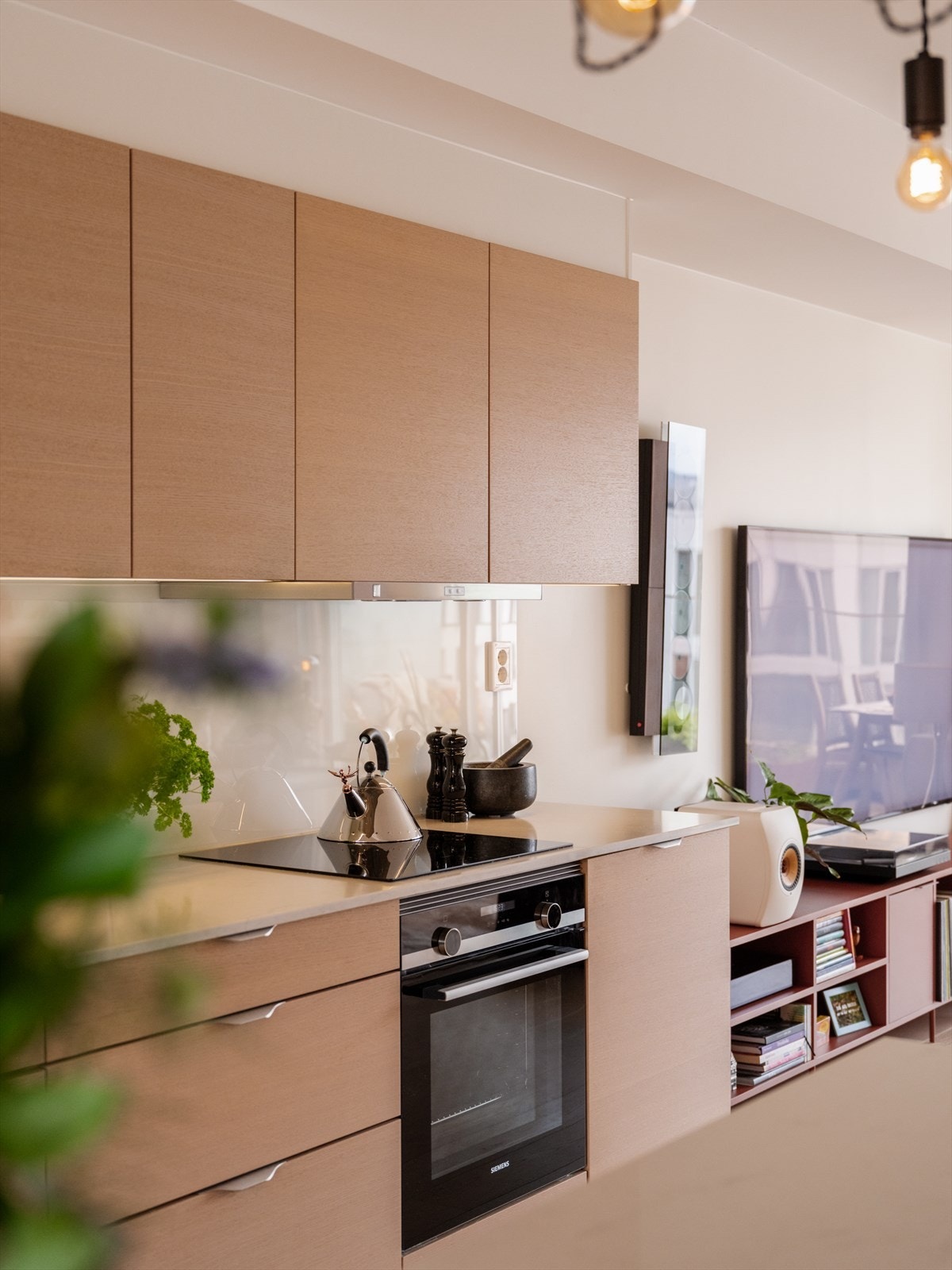 De slette frontene i tidsriktig eikefinér er kombinert med en elegant benkeplate i kompositt, som sammen gir et moderne og tidløst uttrykk. Galleribilde