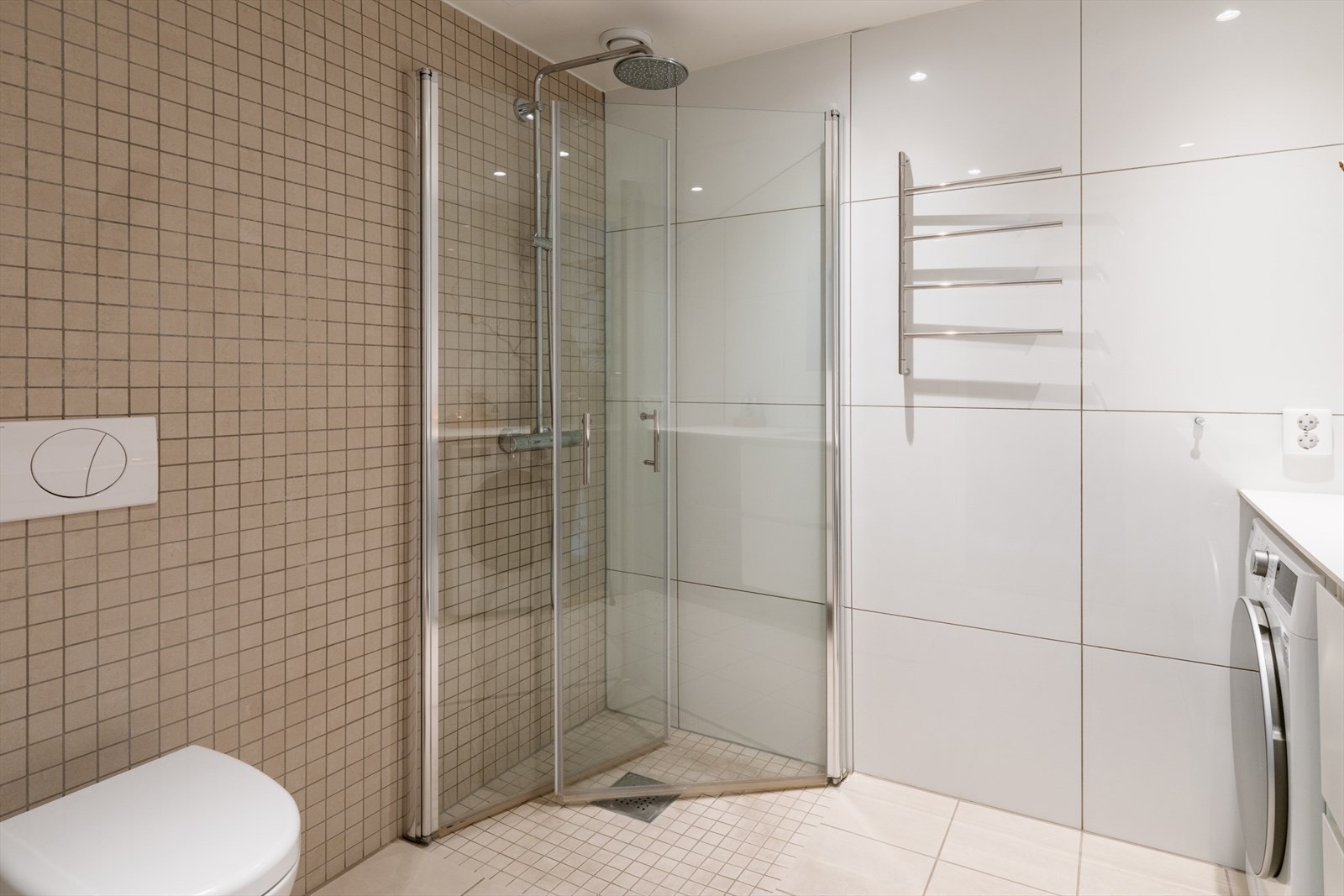 Videre har badet flislagt gulv med vannbåren gulvvarme, flislagte vegger og malt himling med downlights, som sammen skaper et stilrent og behagelig uttrykk. Balansert ventilasjon bidrar til et godt inneklima. Galleribilde