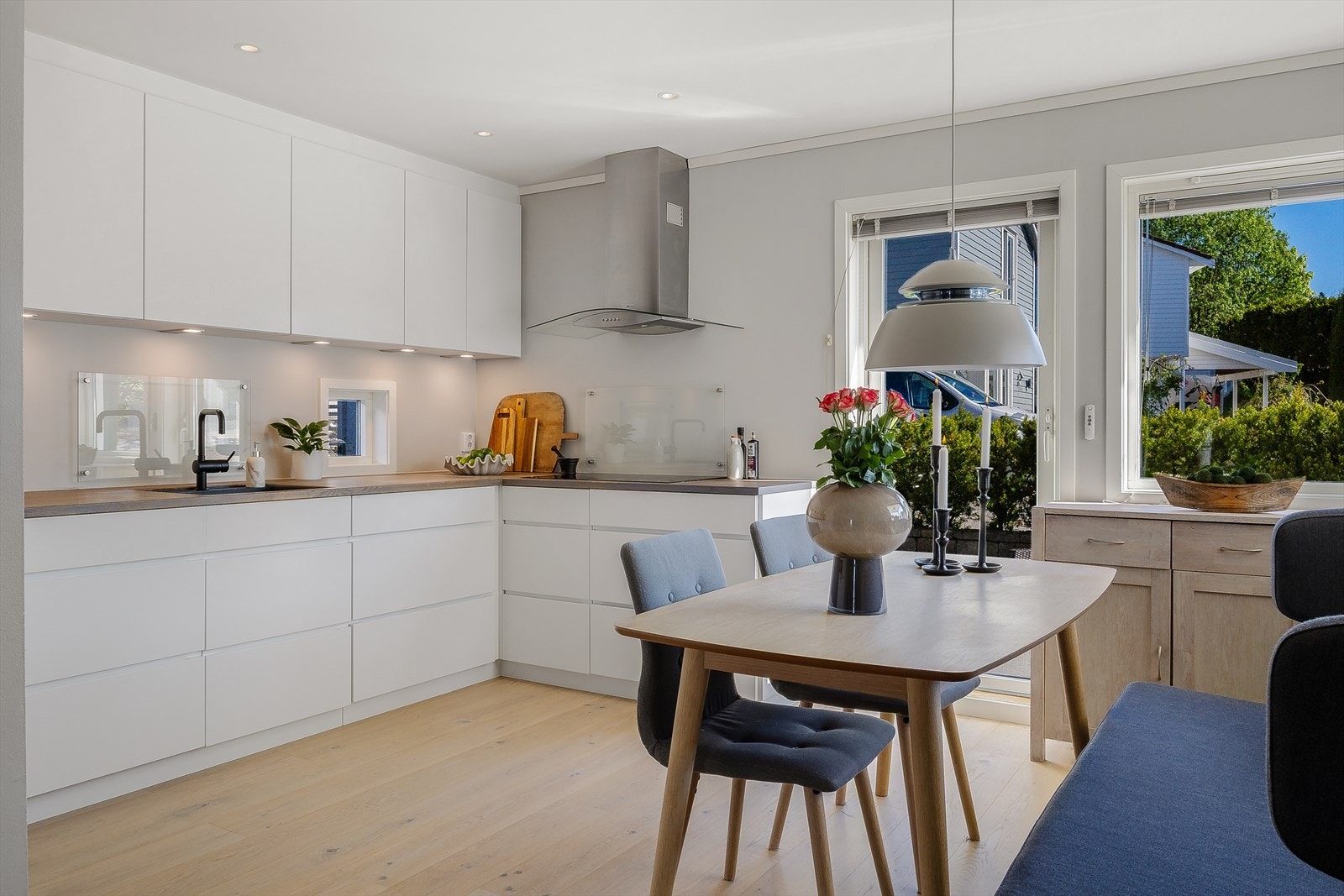Kjøkkenet er med hvite slette fronter, benkeplate i heltre og integrerte hvitevarer fra Siemens. Galleribilde