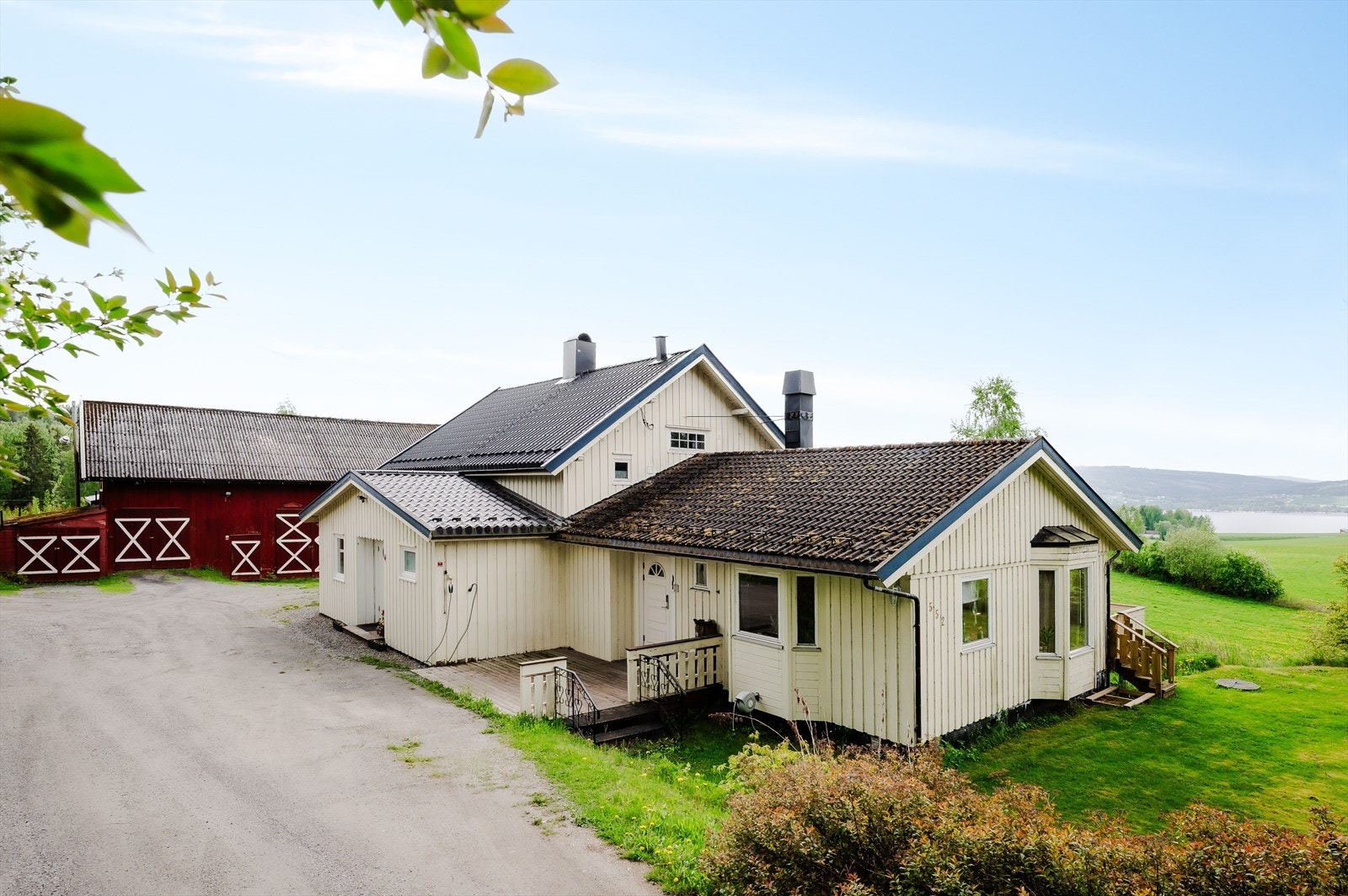 Fasade av bolighus, driftsbygning, samt mjøsutsikt. Galleribilde