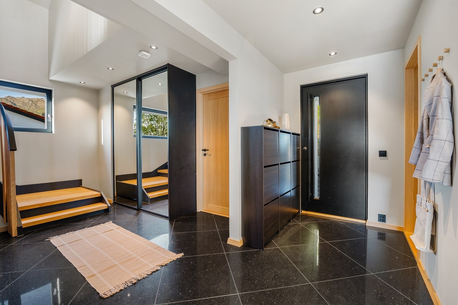 Boligen ønsker deg velkommen med en romslig entré på hele 18 m², hvor elegante materialvalg og gjennomførte detaljer setter tonen allerede ved ankomst. Galleribilde