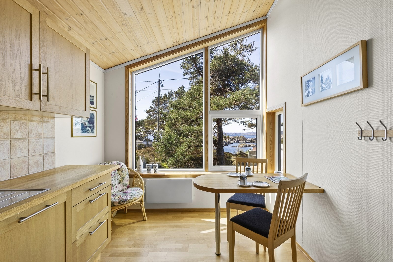 Store vindusflater på kjøkkenet slipper inn rikelig med lys og rammer inn utsikten mot sjøen. Galleribilde