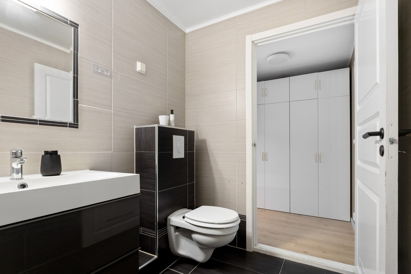 Badet har moderne innredning med vegghengt toalett, heldekkende servant og oppgraderte armaturer fra 2026. Galleribilde