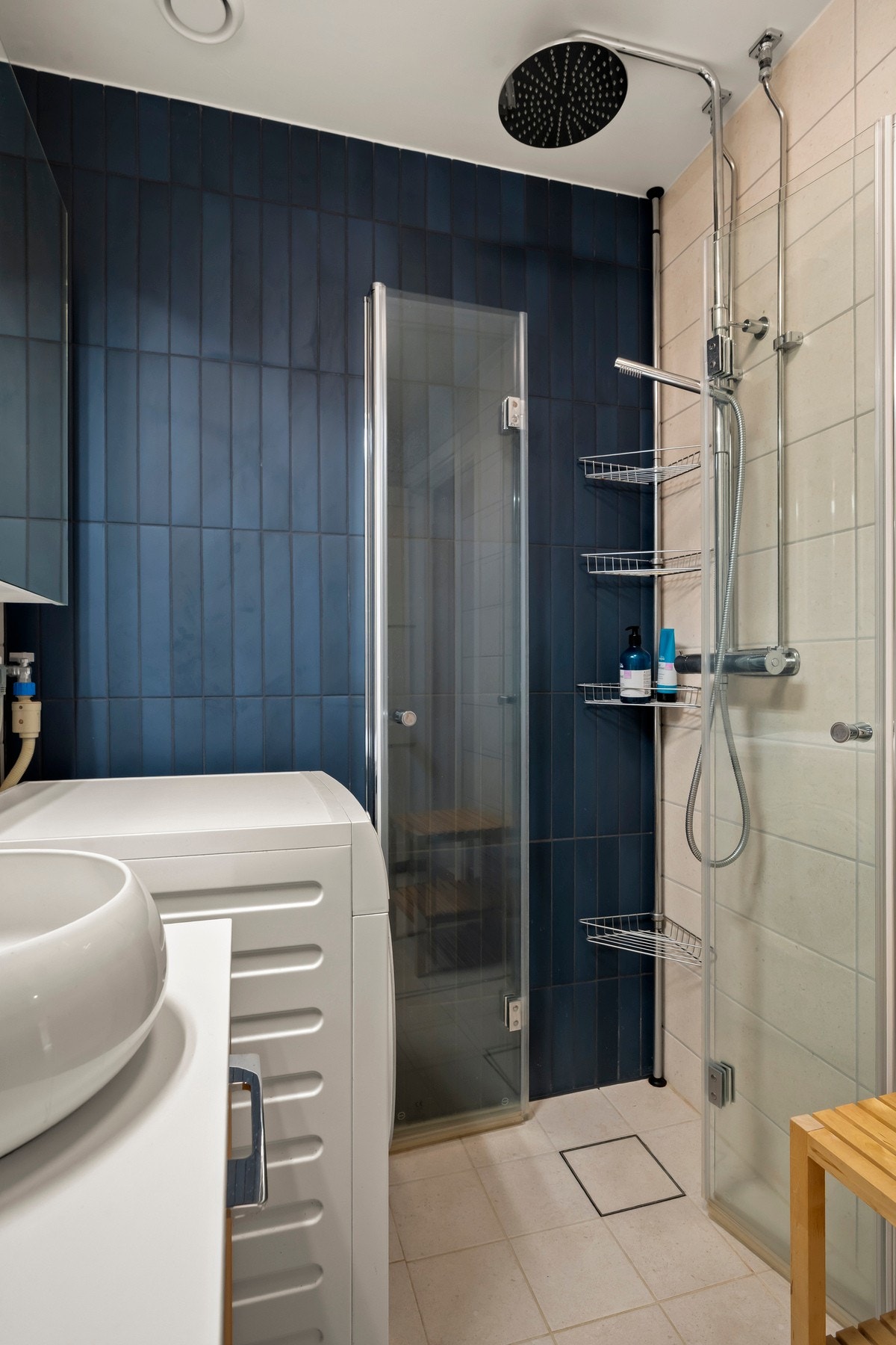 Badet er utstyrt med dusj med innfellbare glassvegger, servantseksjon med skuffer og porselensvask, speilskap med lys og vegghengt wc. Galleribilde