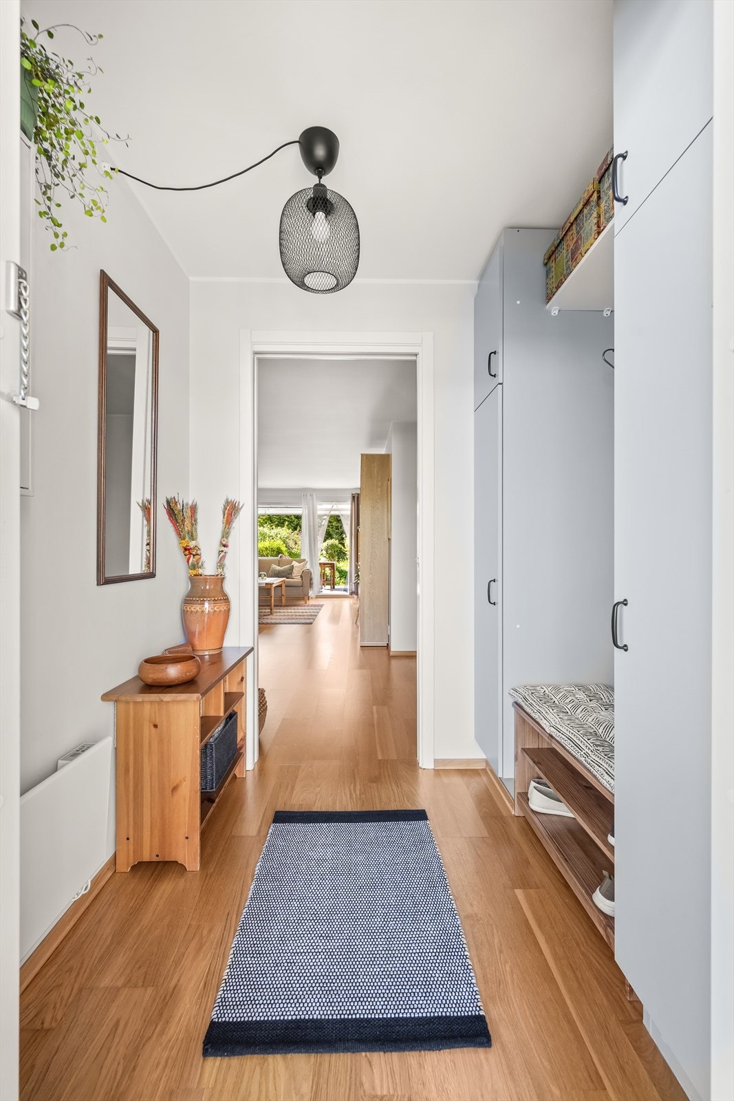 Ytterdøren er utstyrt med kodelås for nøkkelfri adkomst. Inne møter du en romslig entré med garderobeskap langs den ene veggen, med god plass til yttertøy og sko. Galleribilde