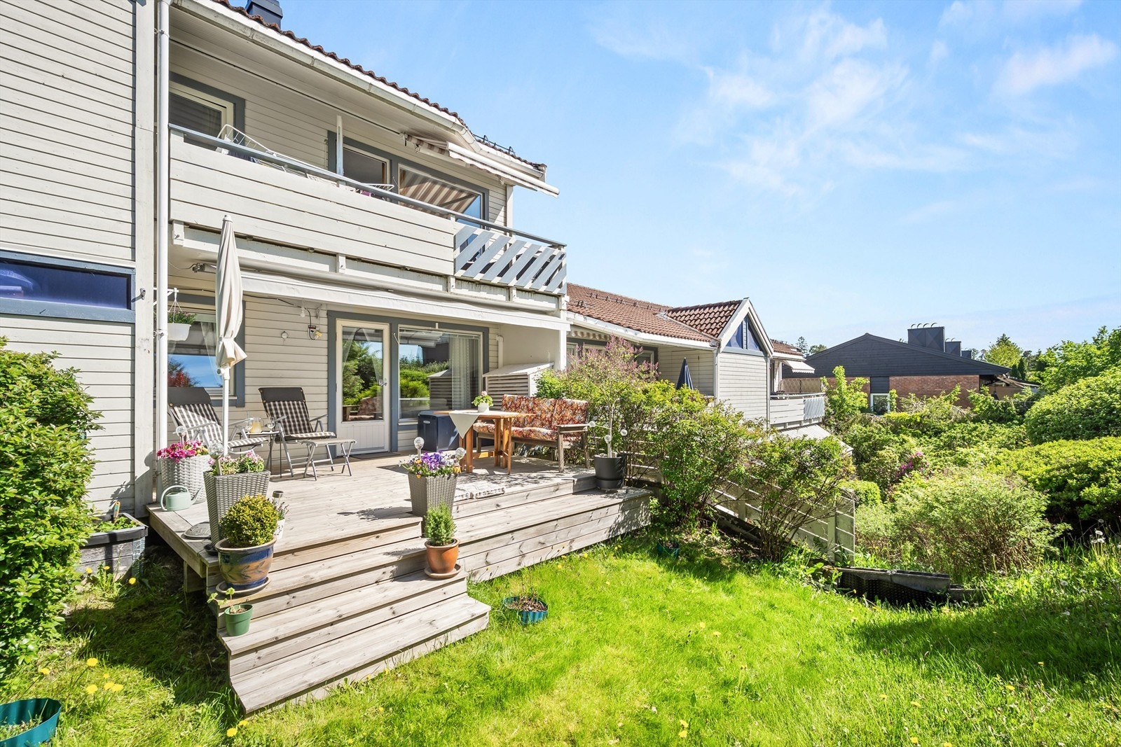 En trapp i trekonstruksjon leder ned til felles hage. Galleribilde